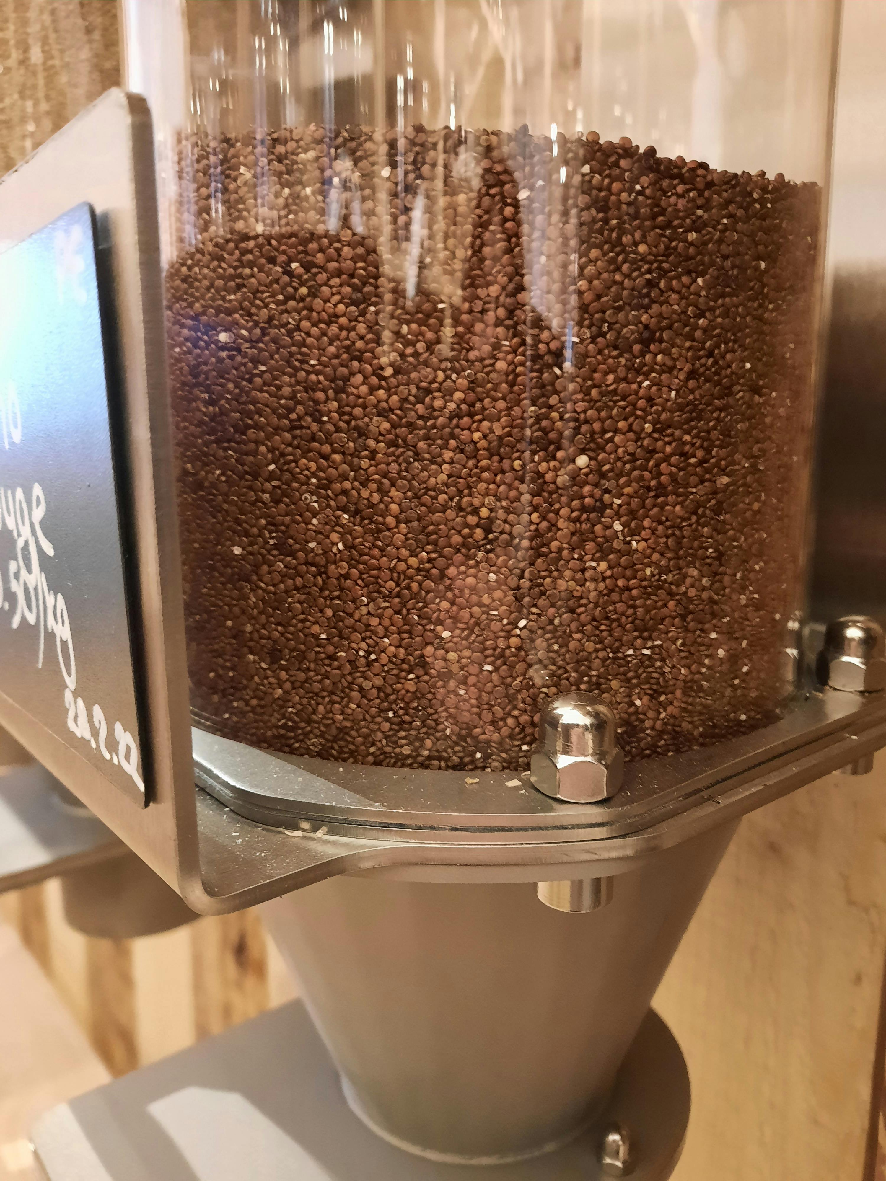 ein Glasbehälter mit braunen Bohnen und einem Schild mit der Aufschrift " frisch "
