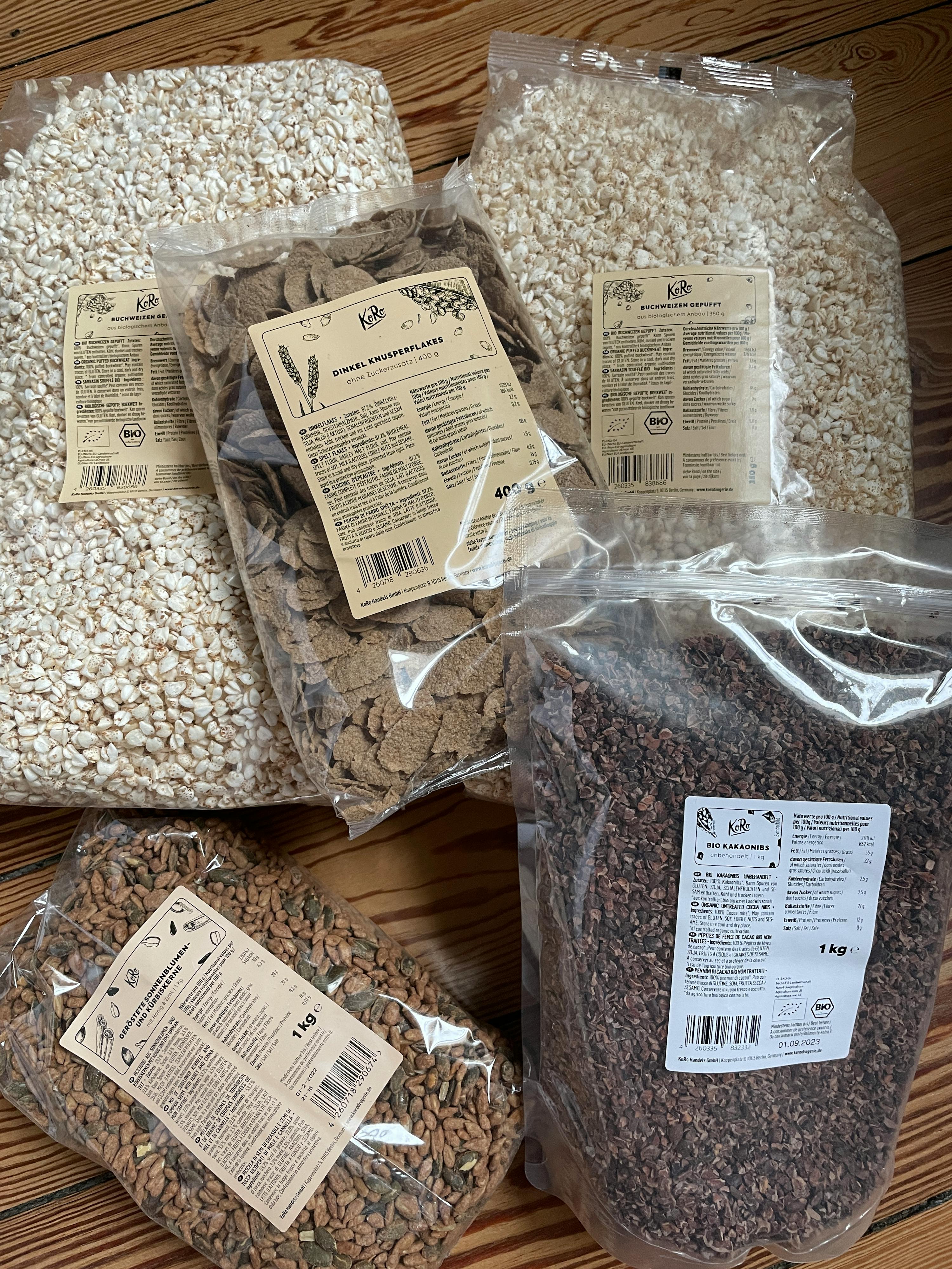 diversi tipi di cereali sono seduti uno accanto all'altro su un pavimento di legno