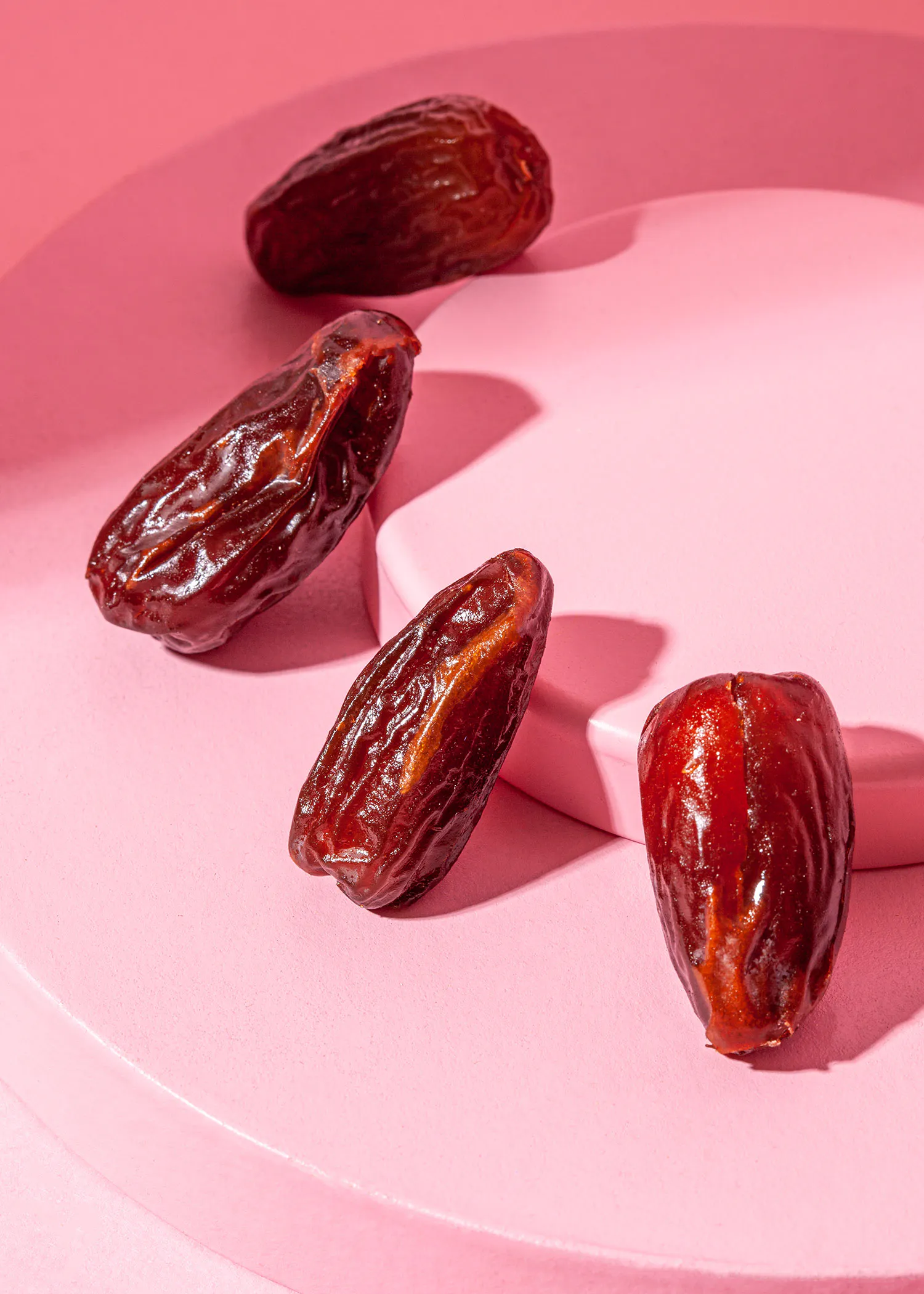 quatre dattes sont assises sur une table rose
