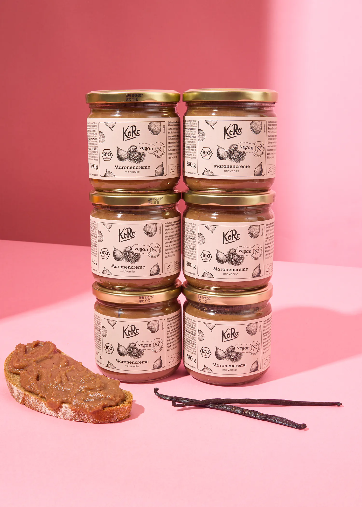 six jars of creme are stacked on top of each other on a pink surface