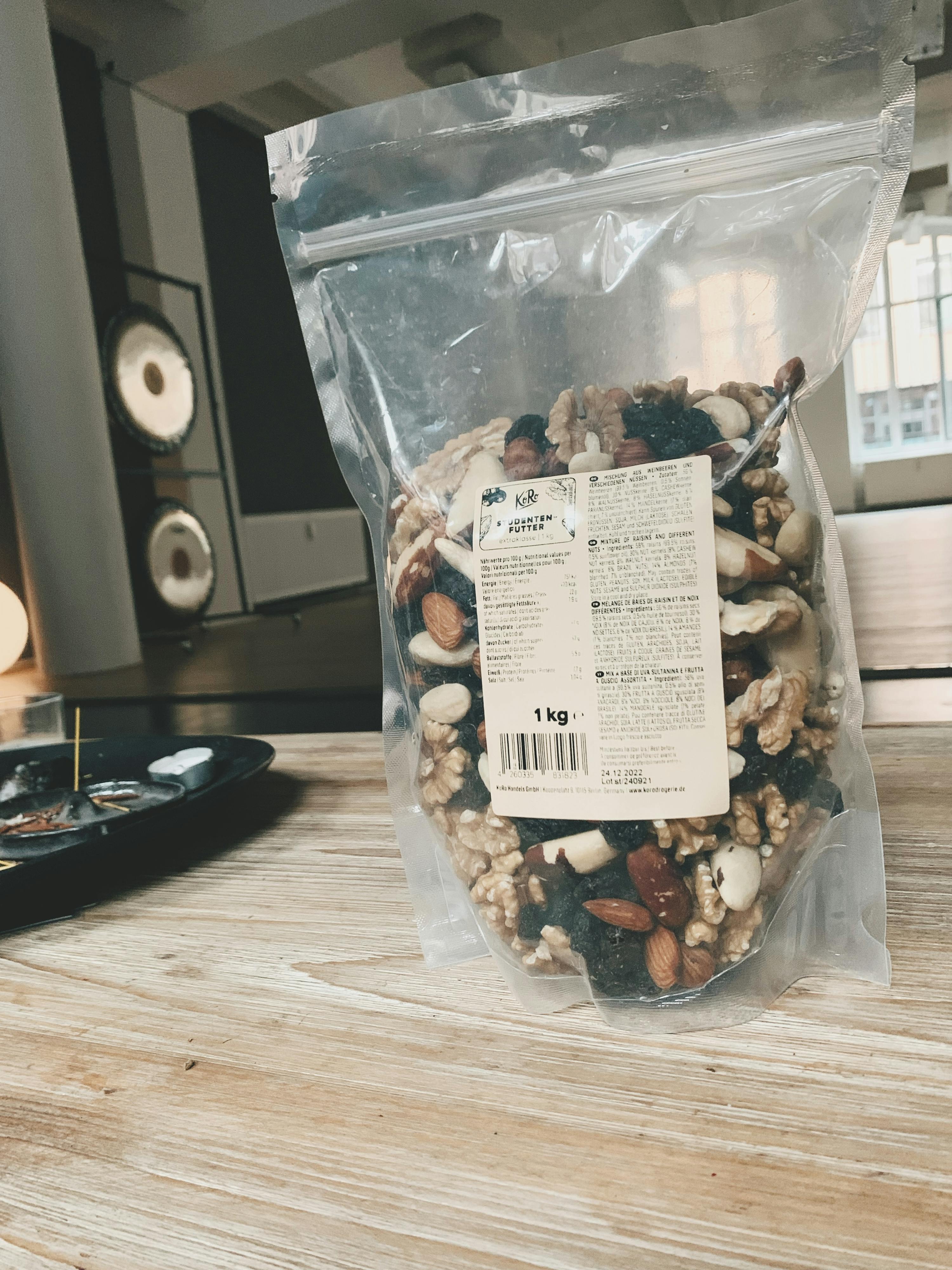 eine Plastiktüte mit Nüssen und Trockenfrüchten steht auf einem Tisch