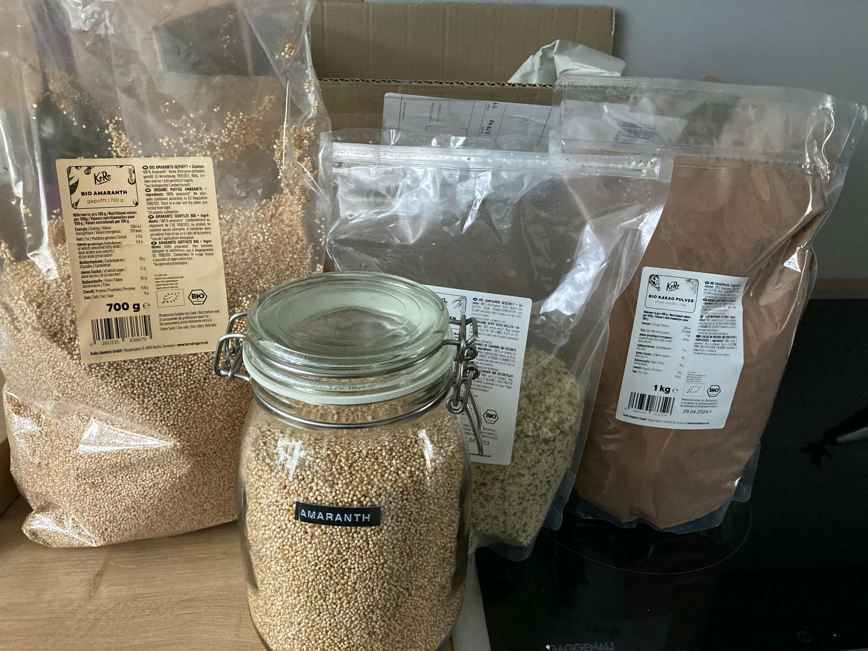 ein Glas voller amaranth steht neben zwei Plastiktüten