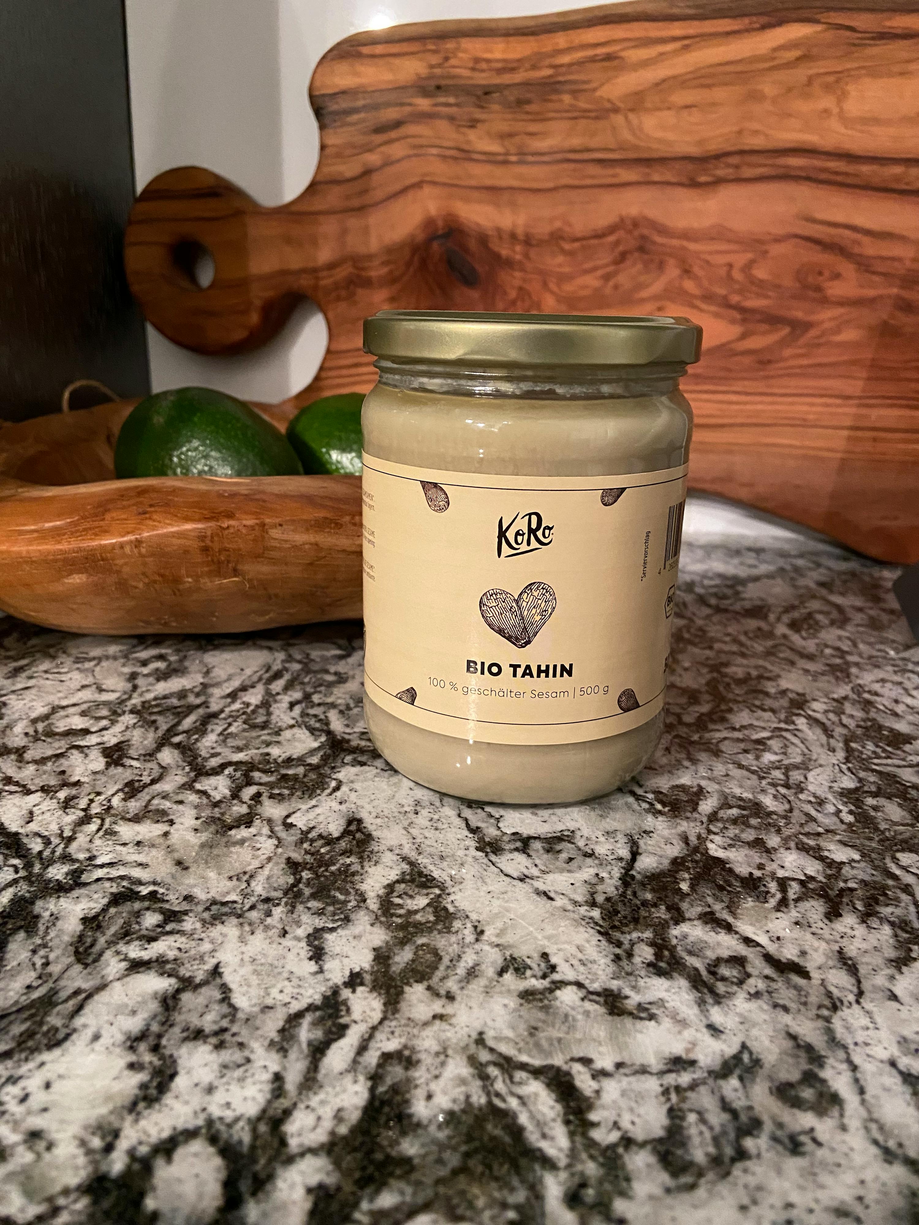 ein Glas Bio-Tahin steht auf einem Schneidebrett
