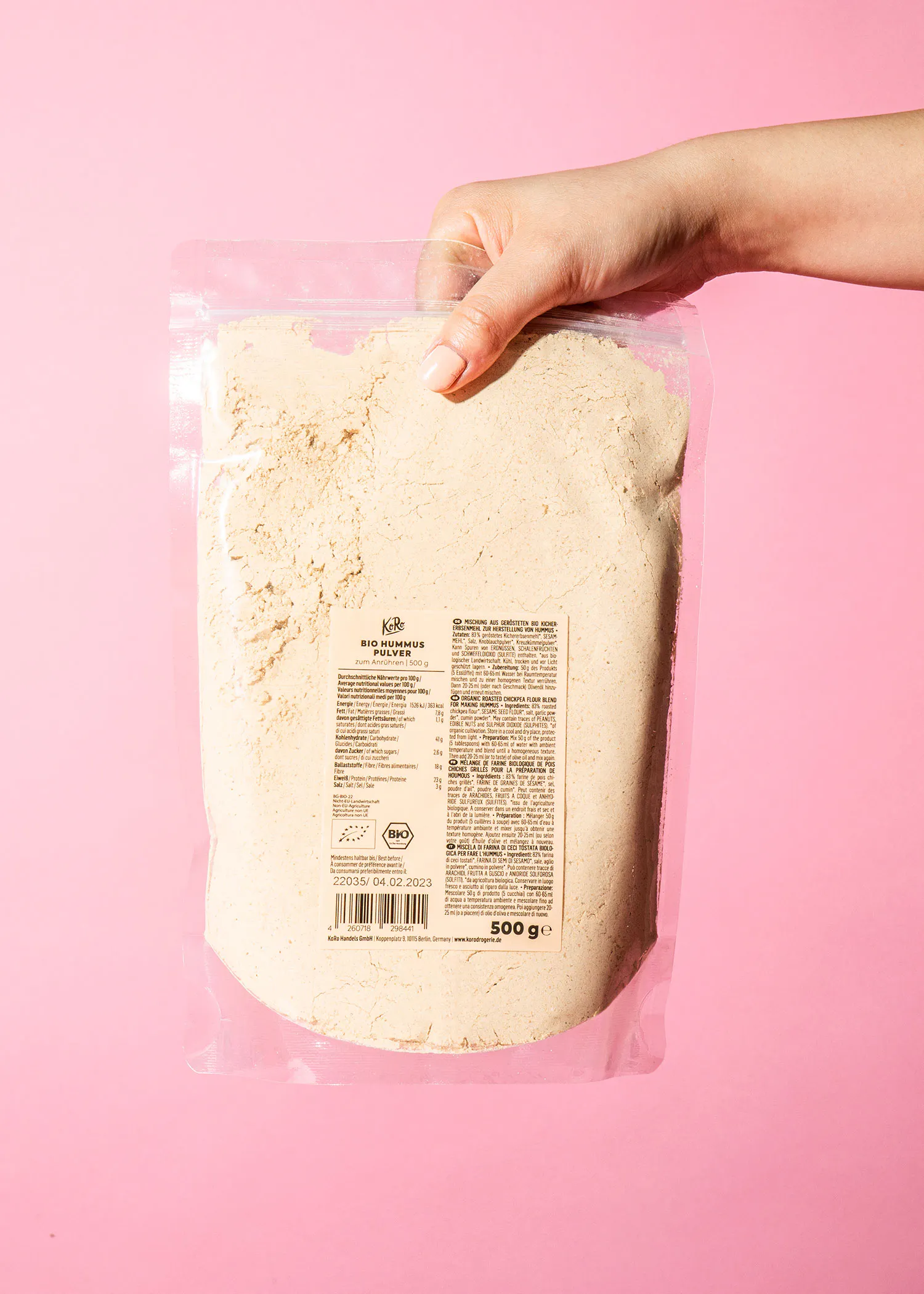 une personne tient un sac en plastique rempli de farine blanche