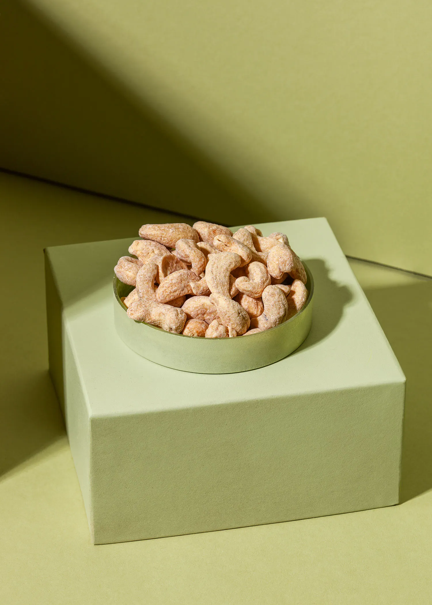 a bowl of nuts sits on a green box