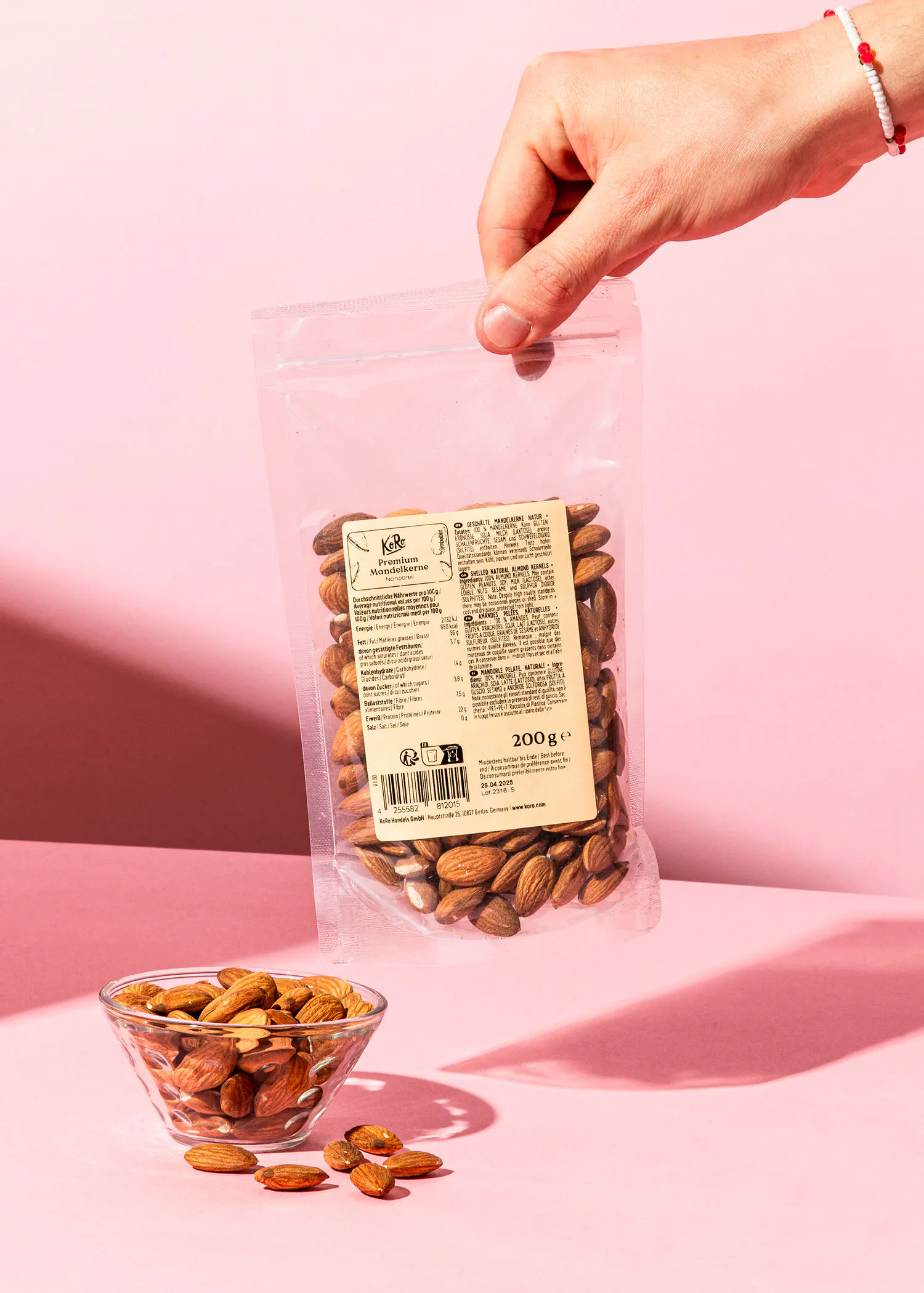 Eine Person hält einen Plastikbeutel mit Mandeln in der Hand