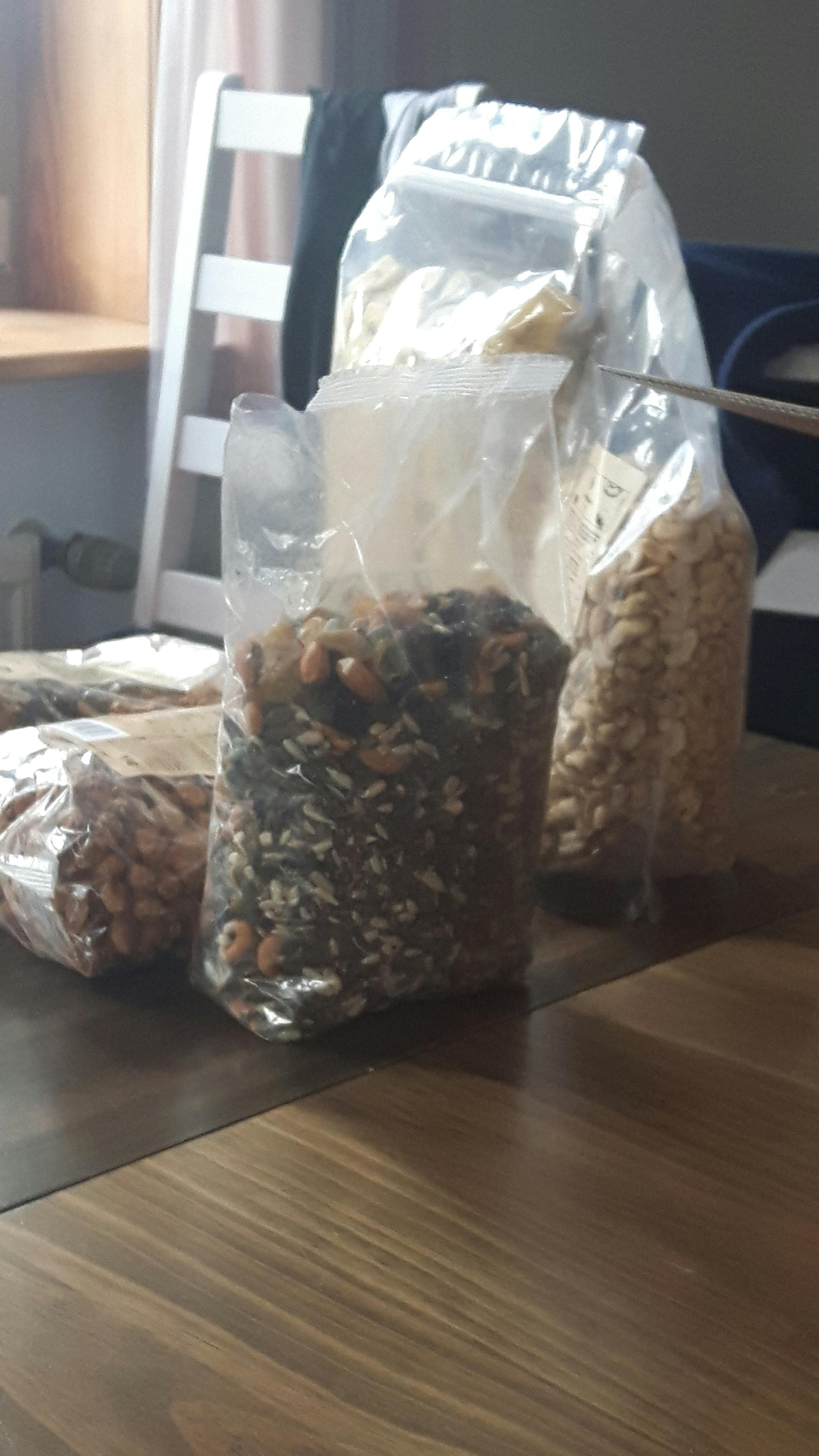 auf einem holztisch stehen drei beutel mit trockenfrüchten