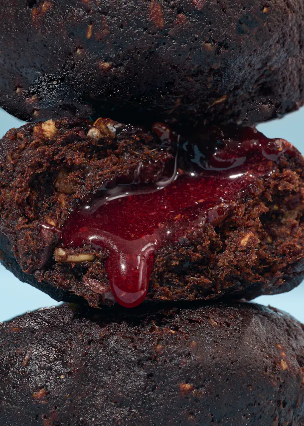 eine Nahaufnahme eines Schokoladenkuchens mit Himbeermarmelade darauf