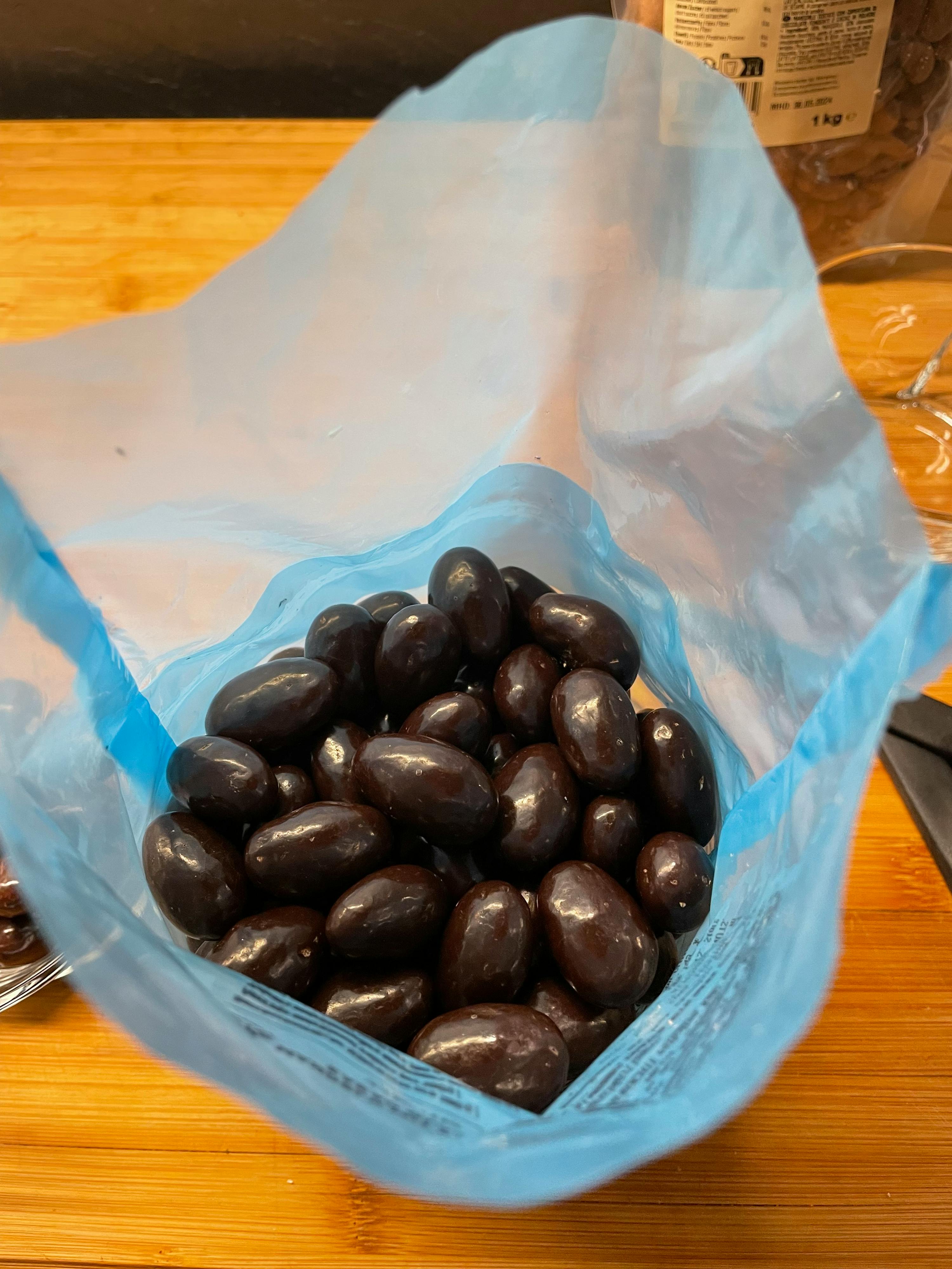 eine blaue Plastiktüte voller Schokoladenüberzogener Walnüsse