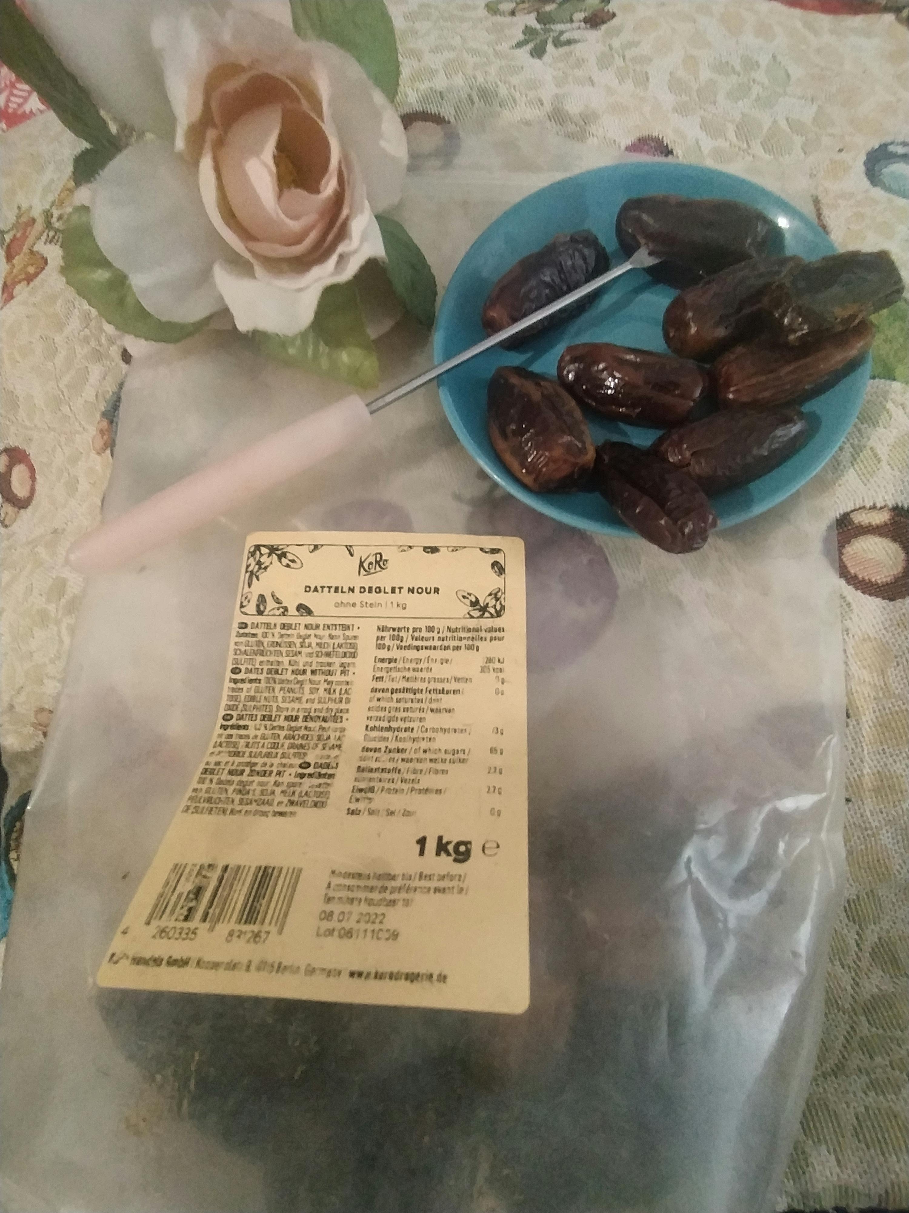 eine Tüte Datteln steht neben einem Teller mit Datteln
