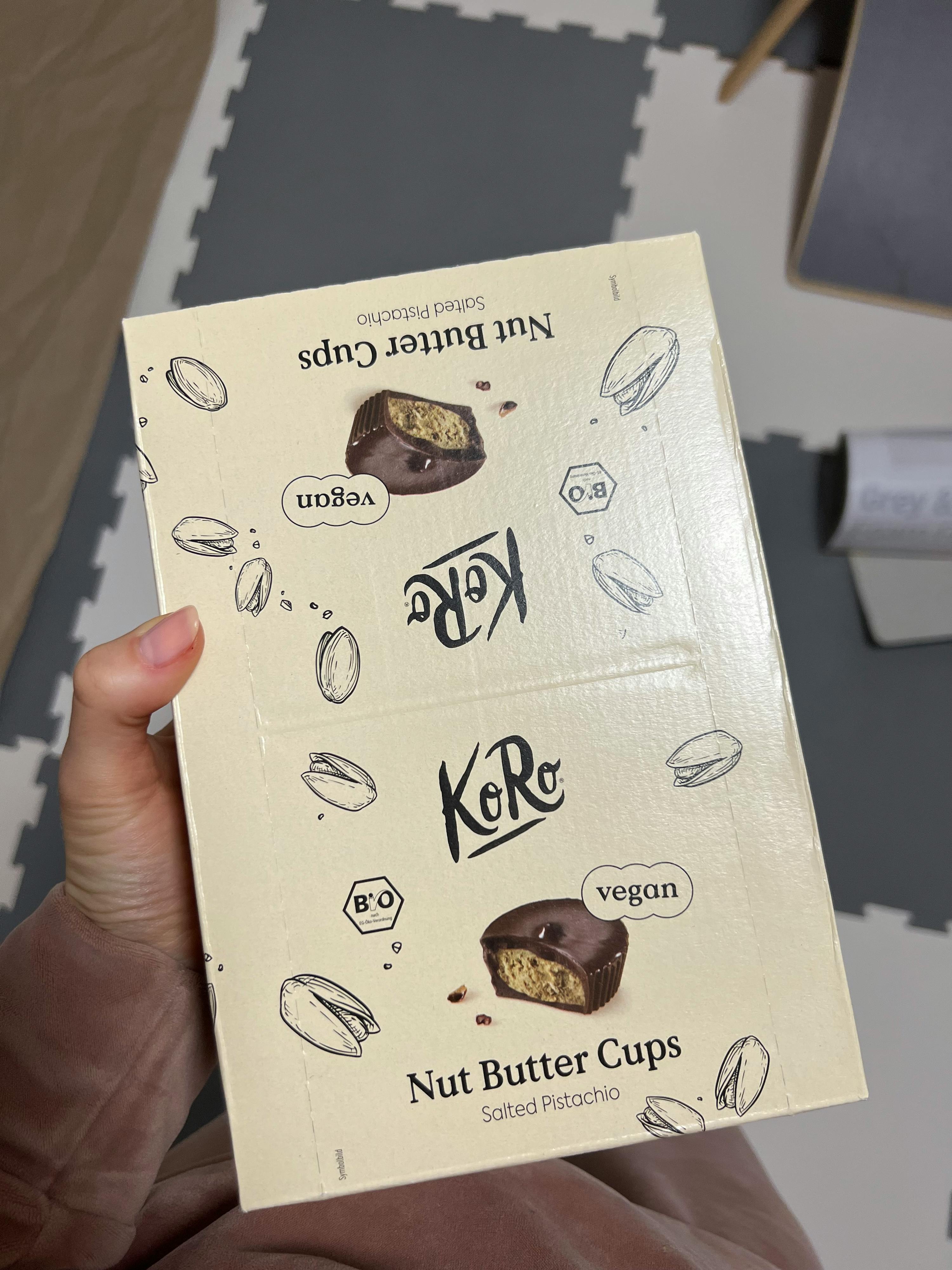 a person is holding a box of vegan nut butter cups