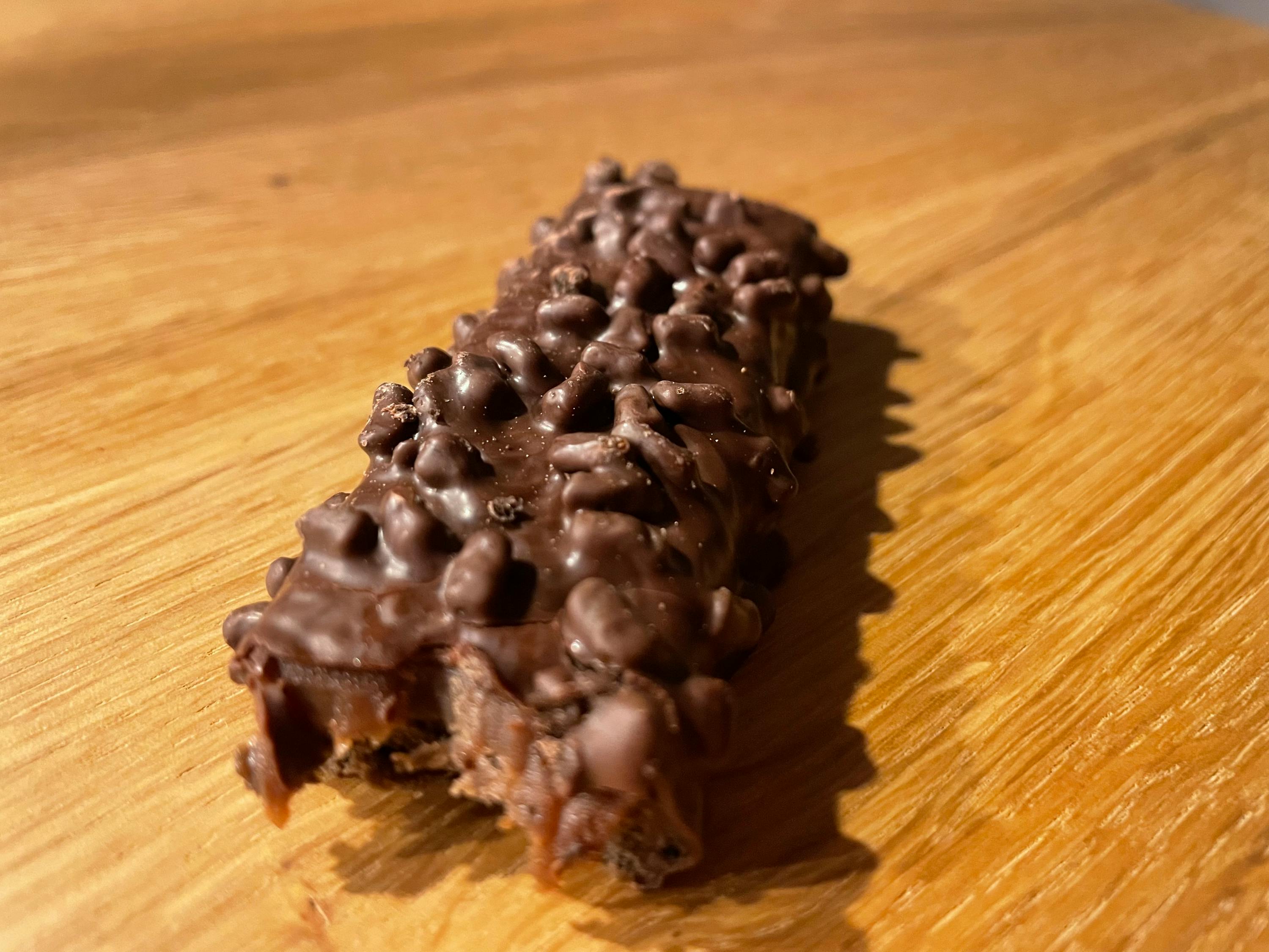 une barre de chocolat est posée sur une surface en bois