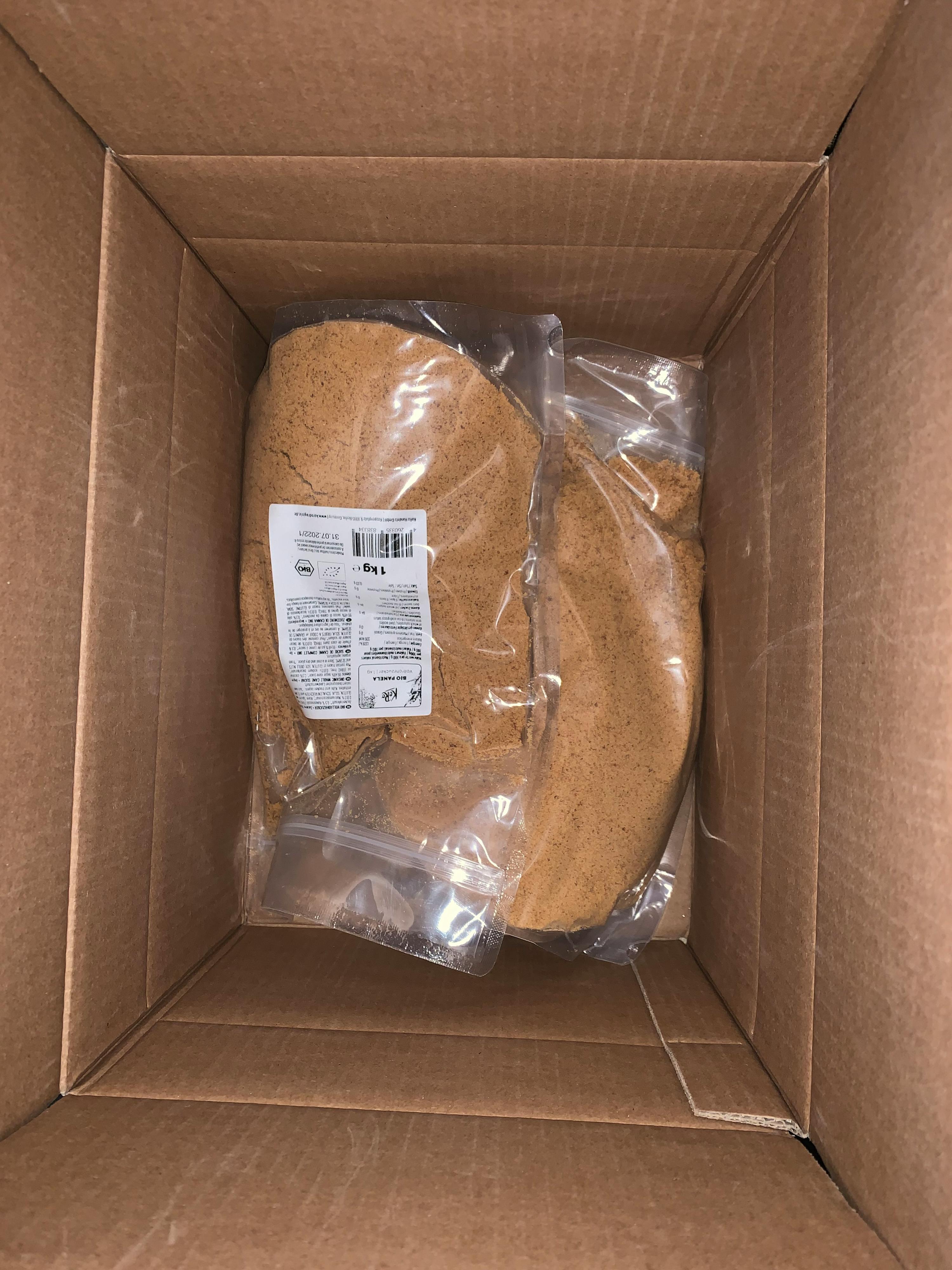 a cardboard box with two bags of brown powder in it