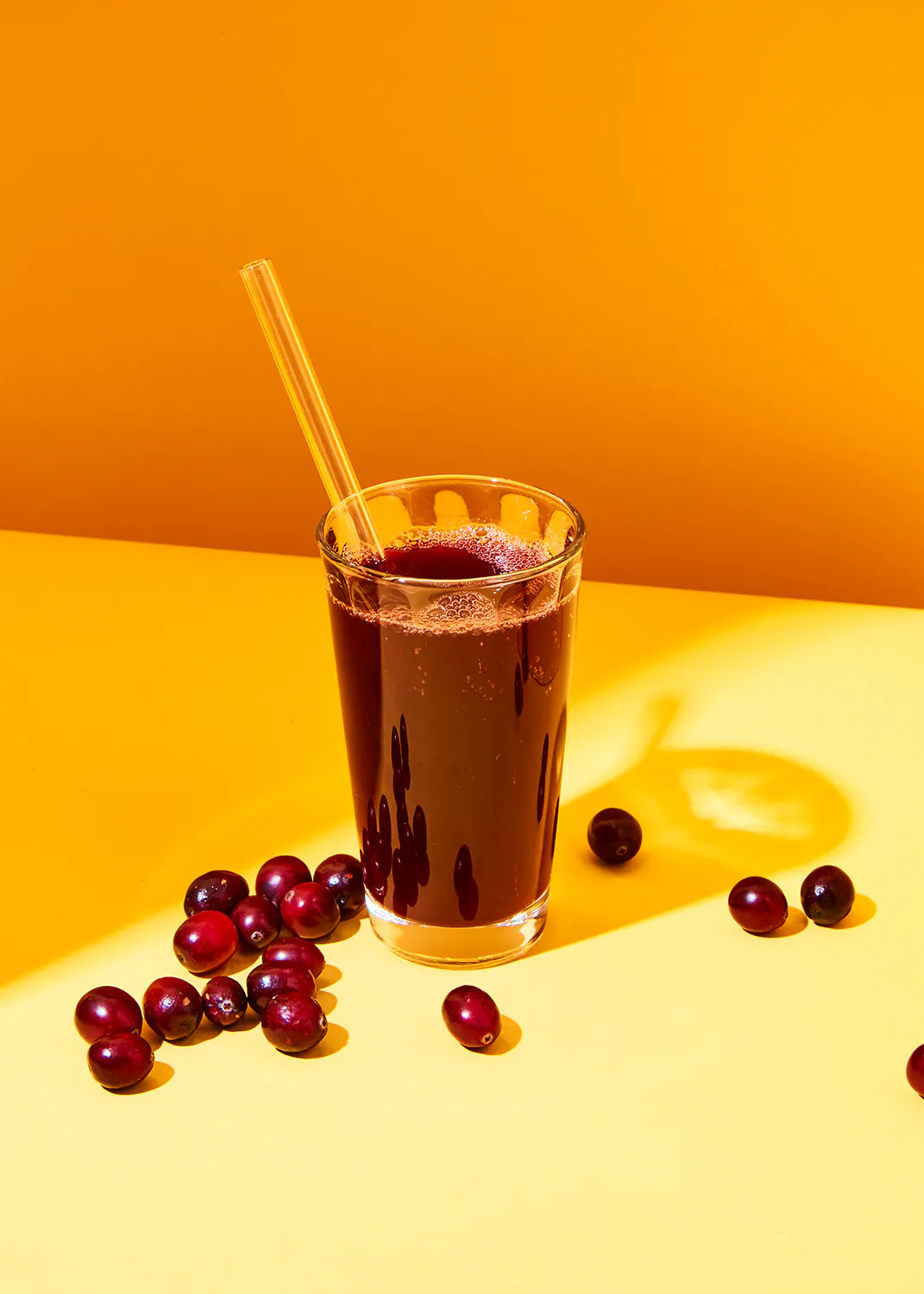 un verre de jus de canneberge avec une paille