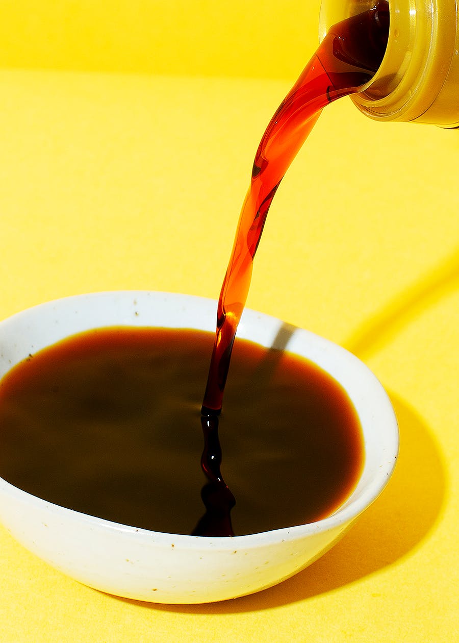 Organic soy sauce 1L a brown liquid is poured into a white bowl
