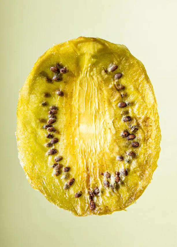 une tranche de kiwi jaune avec des graines brunes