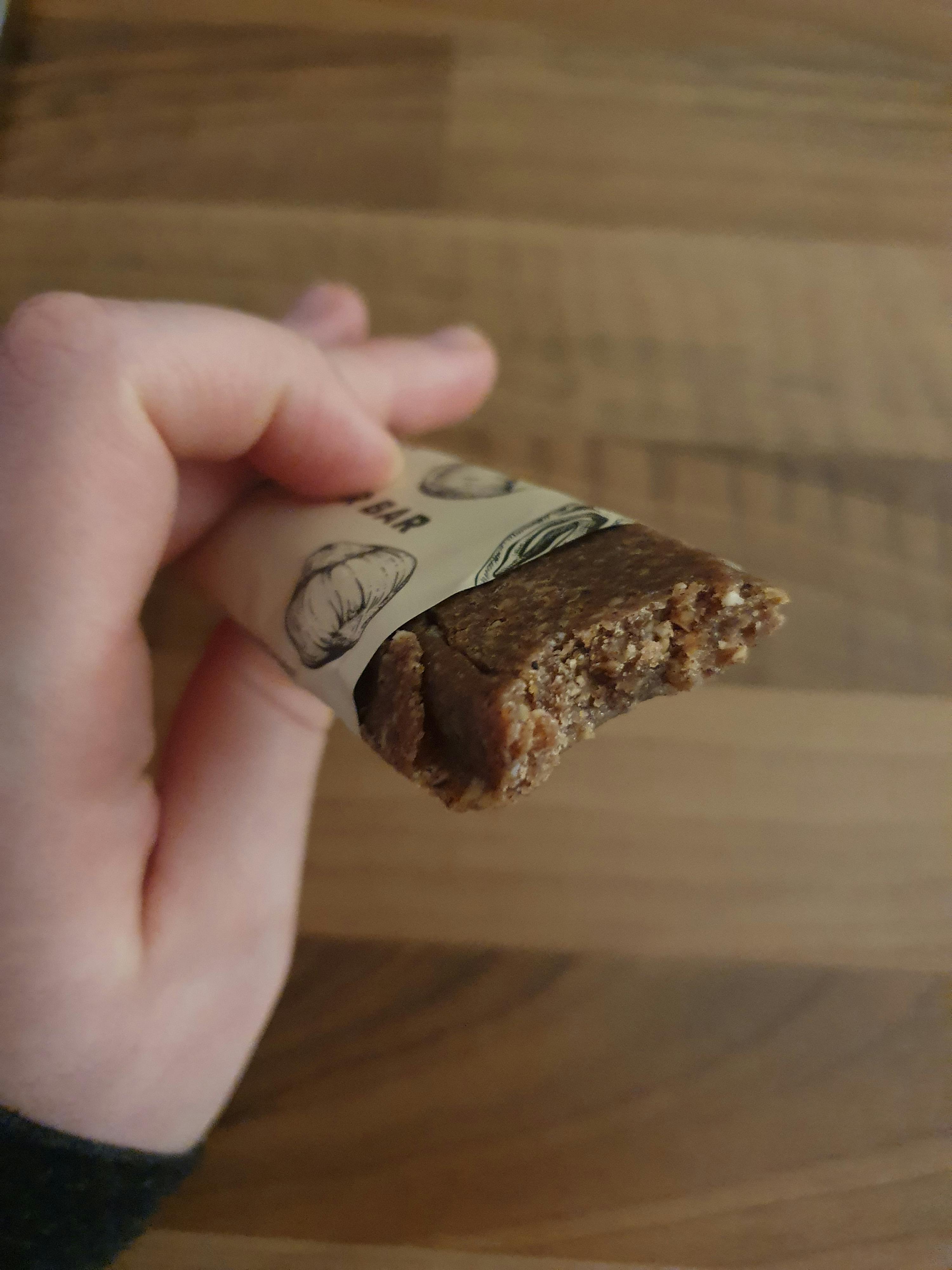 a person holding a bar with a bite taken out of it