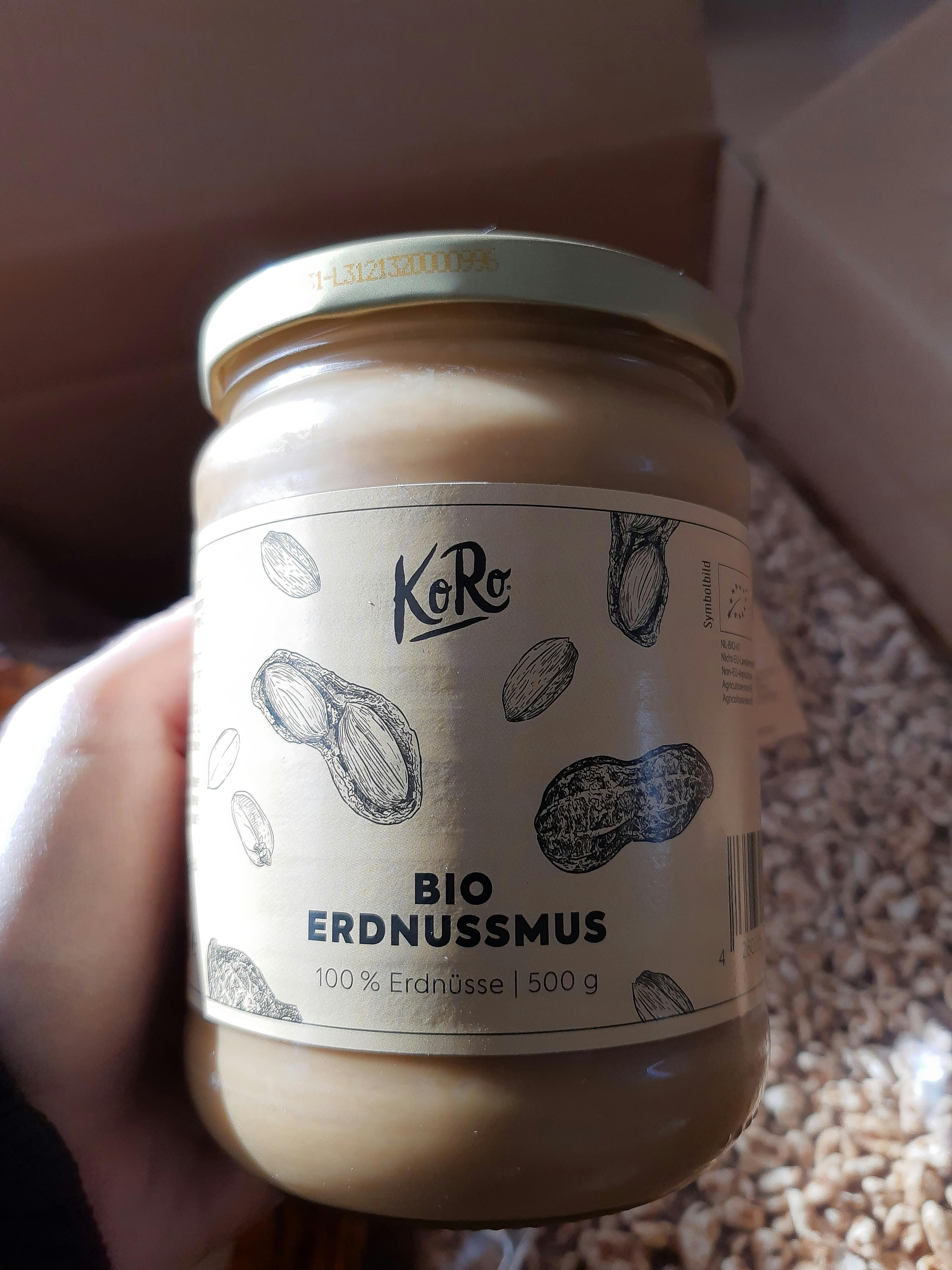 a jar of bio erdnussmus is being held in someone 's hand