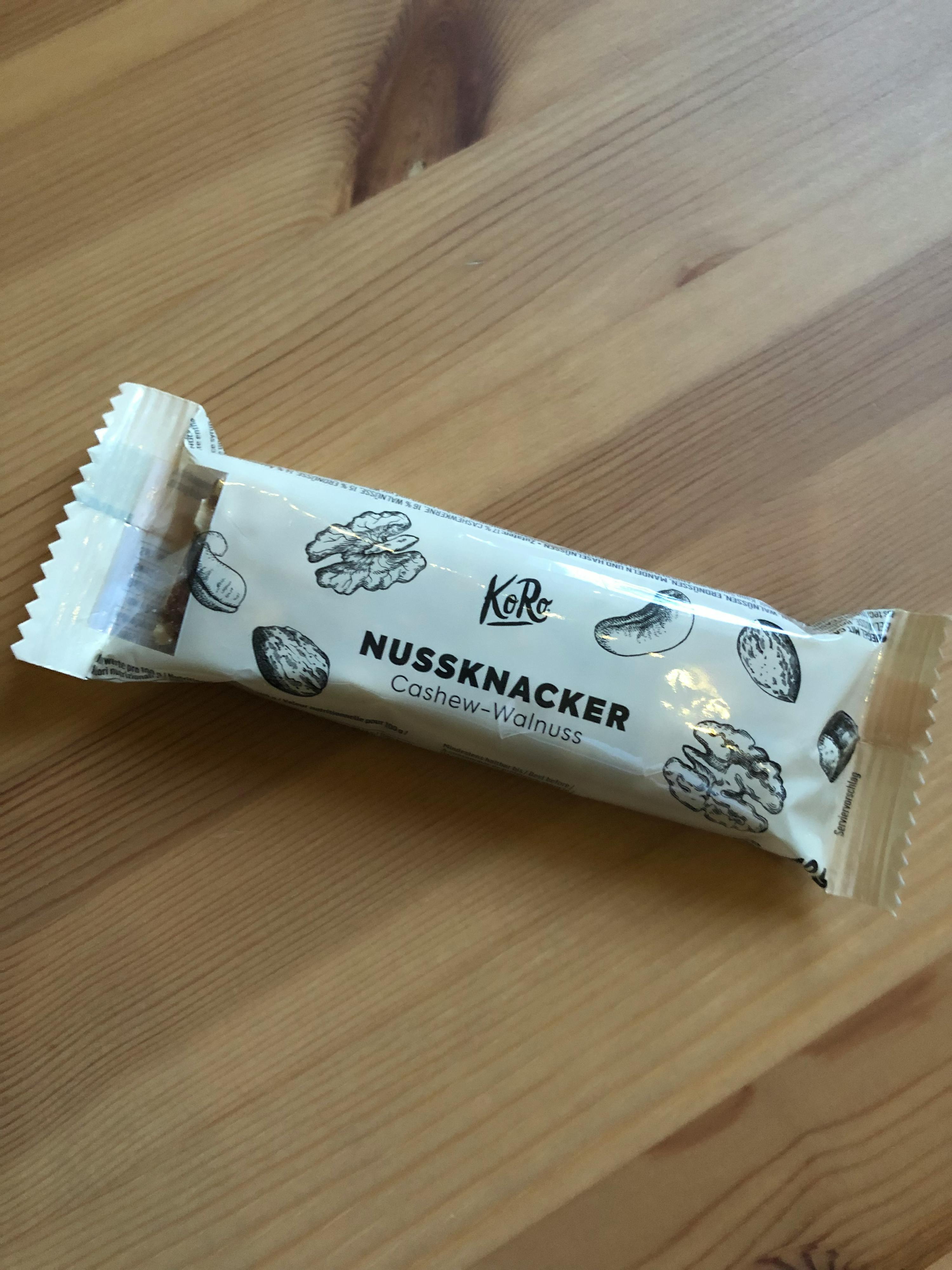 auf einem holztisch steht ein nussnacker mit cashew-nuss