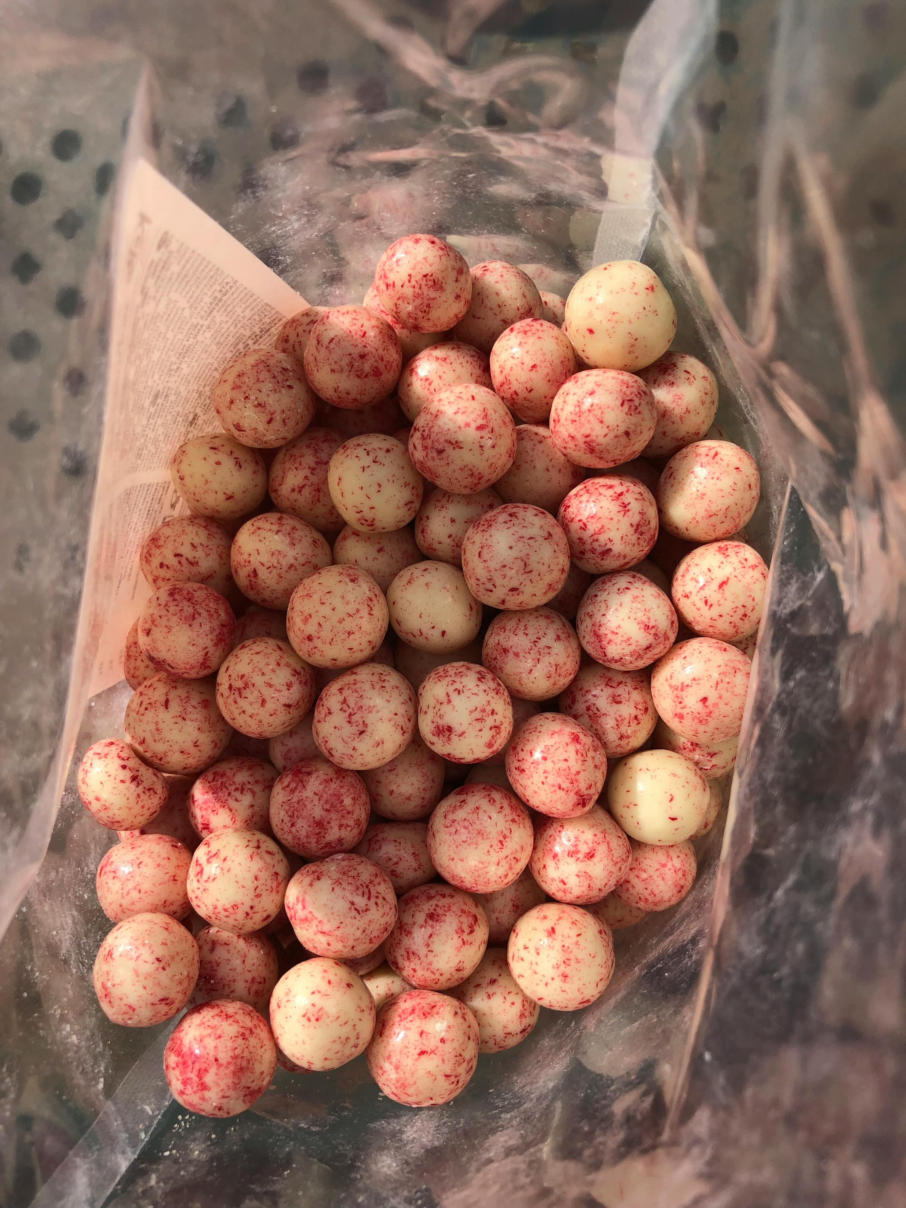 un sacchetto pieno di palline rosse e bianche su un giornale