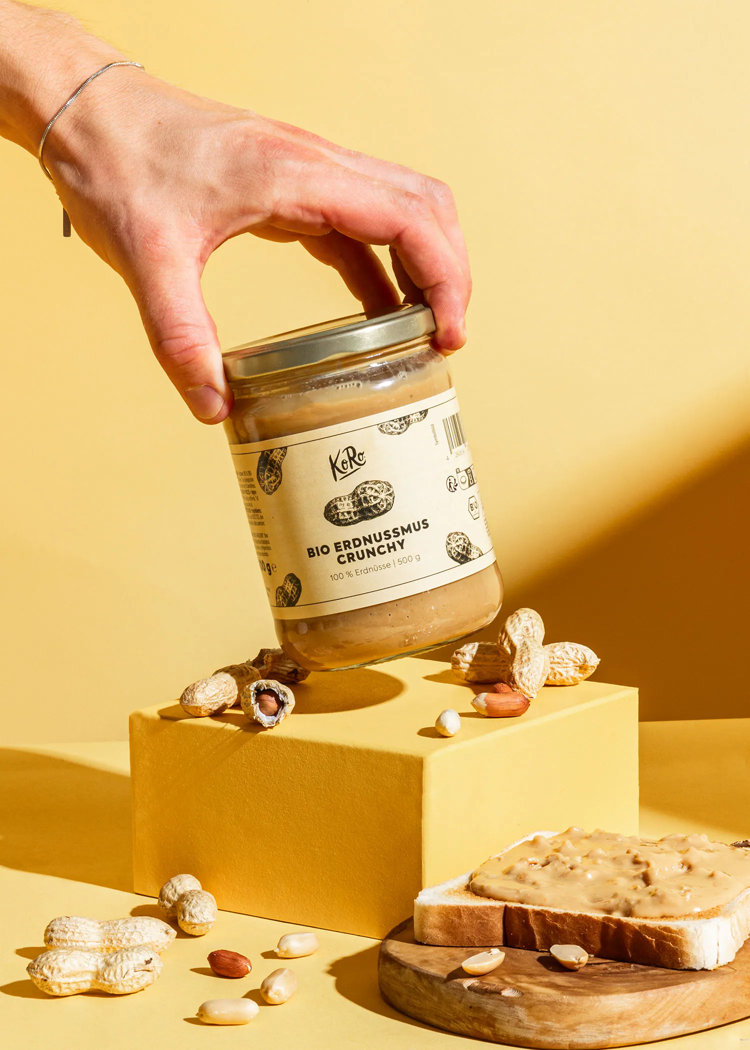 une personne tient un bocal de beurre d' arachide bio