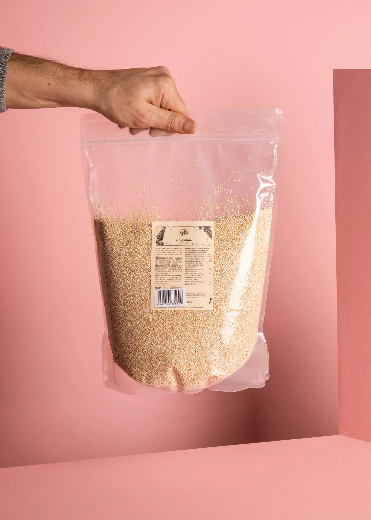une personne tient un sac en plastique rempli de quinoa