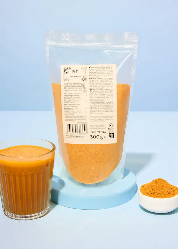 eine Tüte kurkumapulver steht neben einem Glas