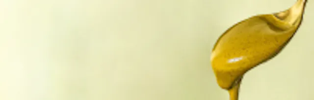 eine Nahaufnahme einer gelben Flüssigkeit , die aus einem Löffel fließt