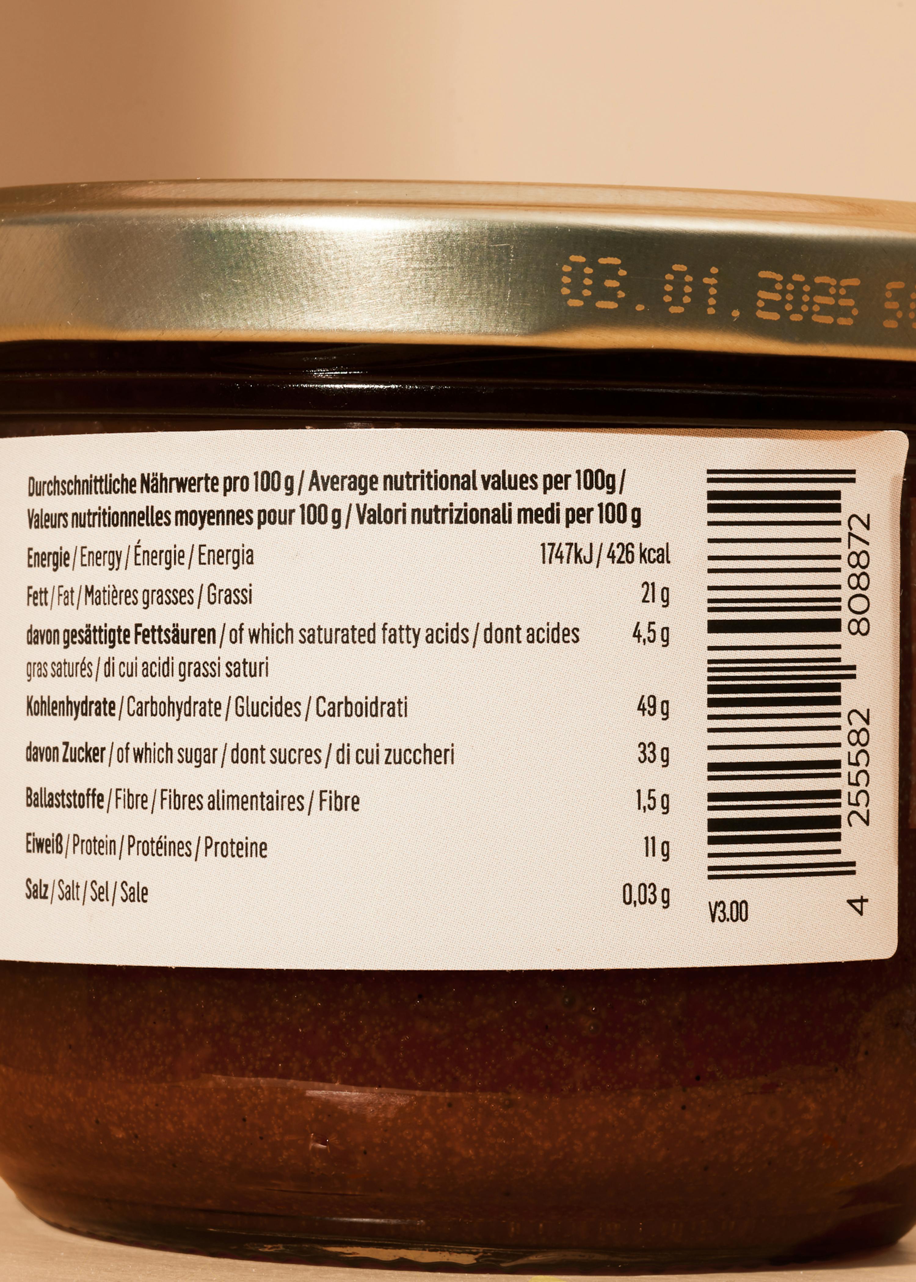 a close-up of a food jar's nutritional label showing average values per 100g, a barcode, and a best-before date of 03.01.2025.