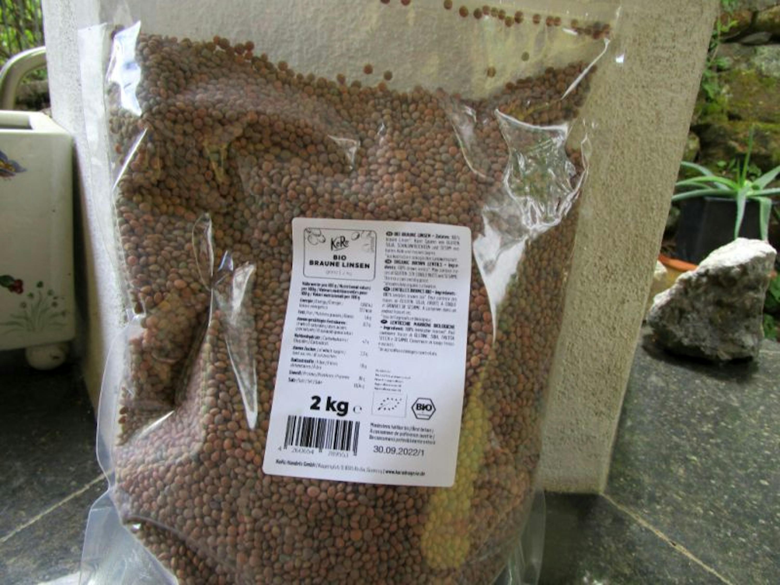 un sac de lentilles brunes avec une étiquette bio