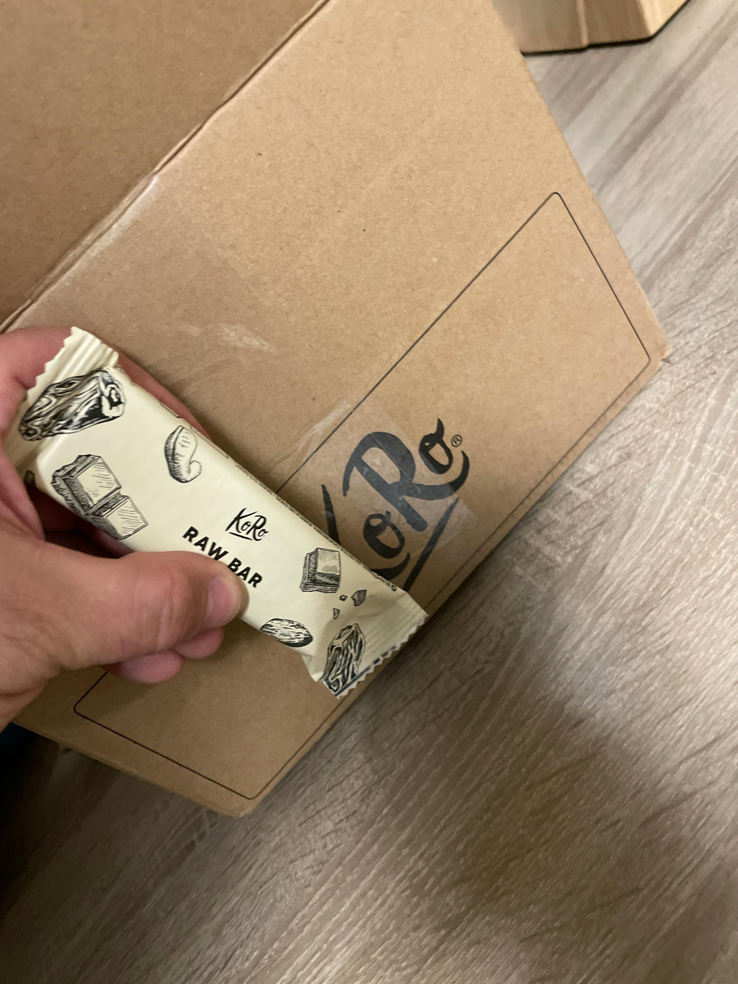 a person holding a raw bar in front of a box