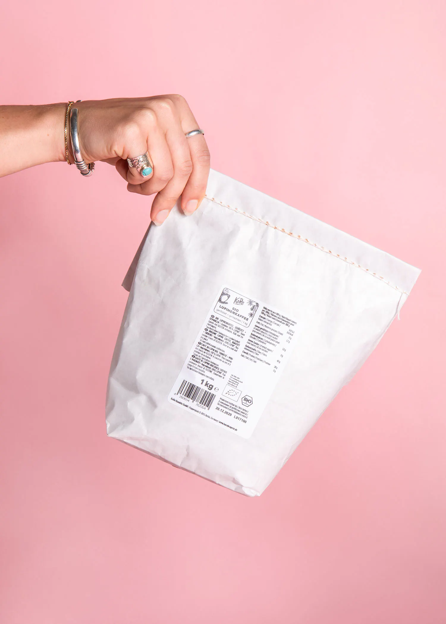 une personne tient un sac blanc avec une étiquette qui dit 1 kg