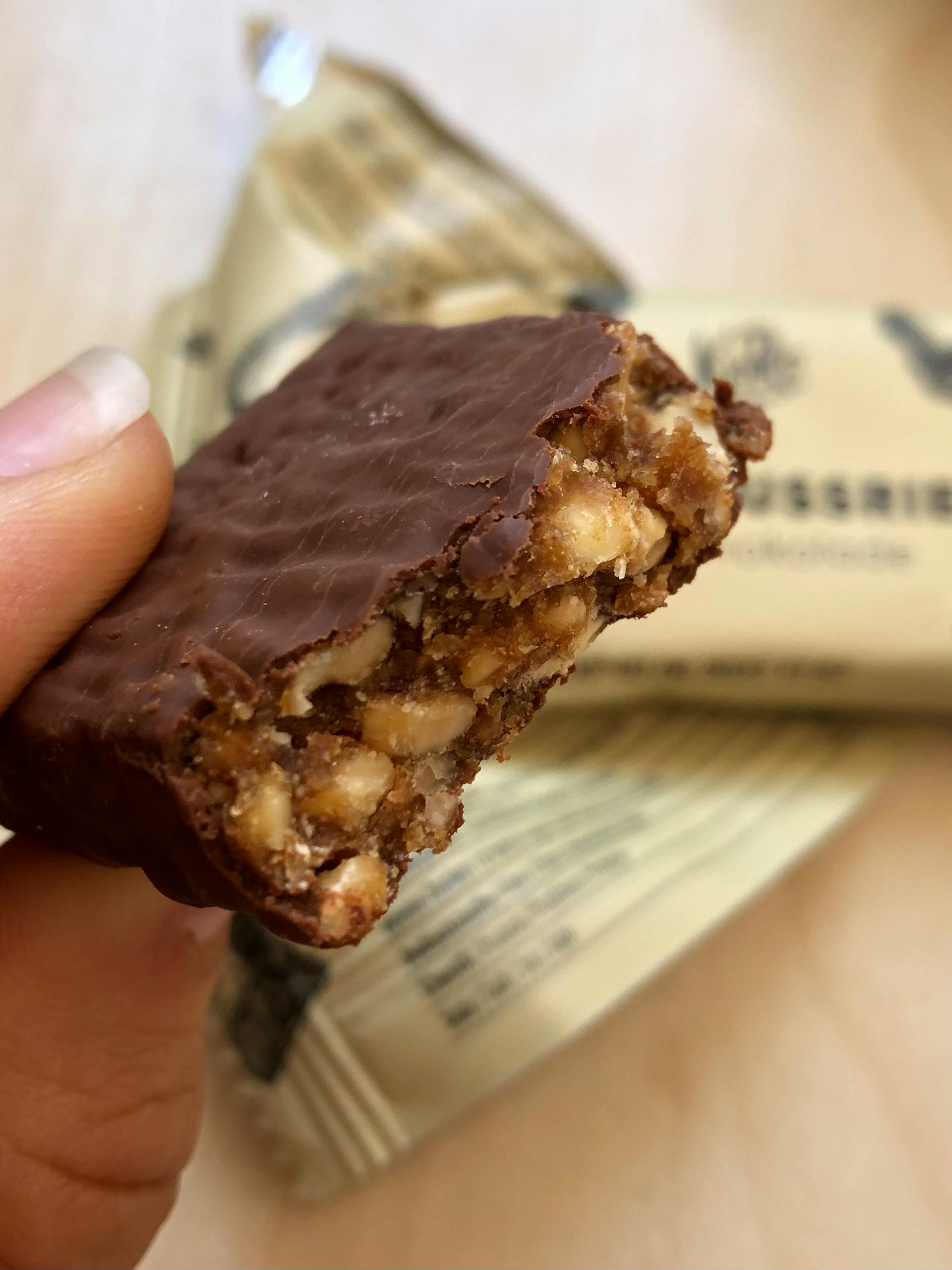 une personne tient une barre de chocolat avec une bouchée sortie