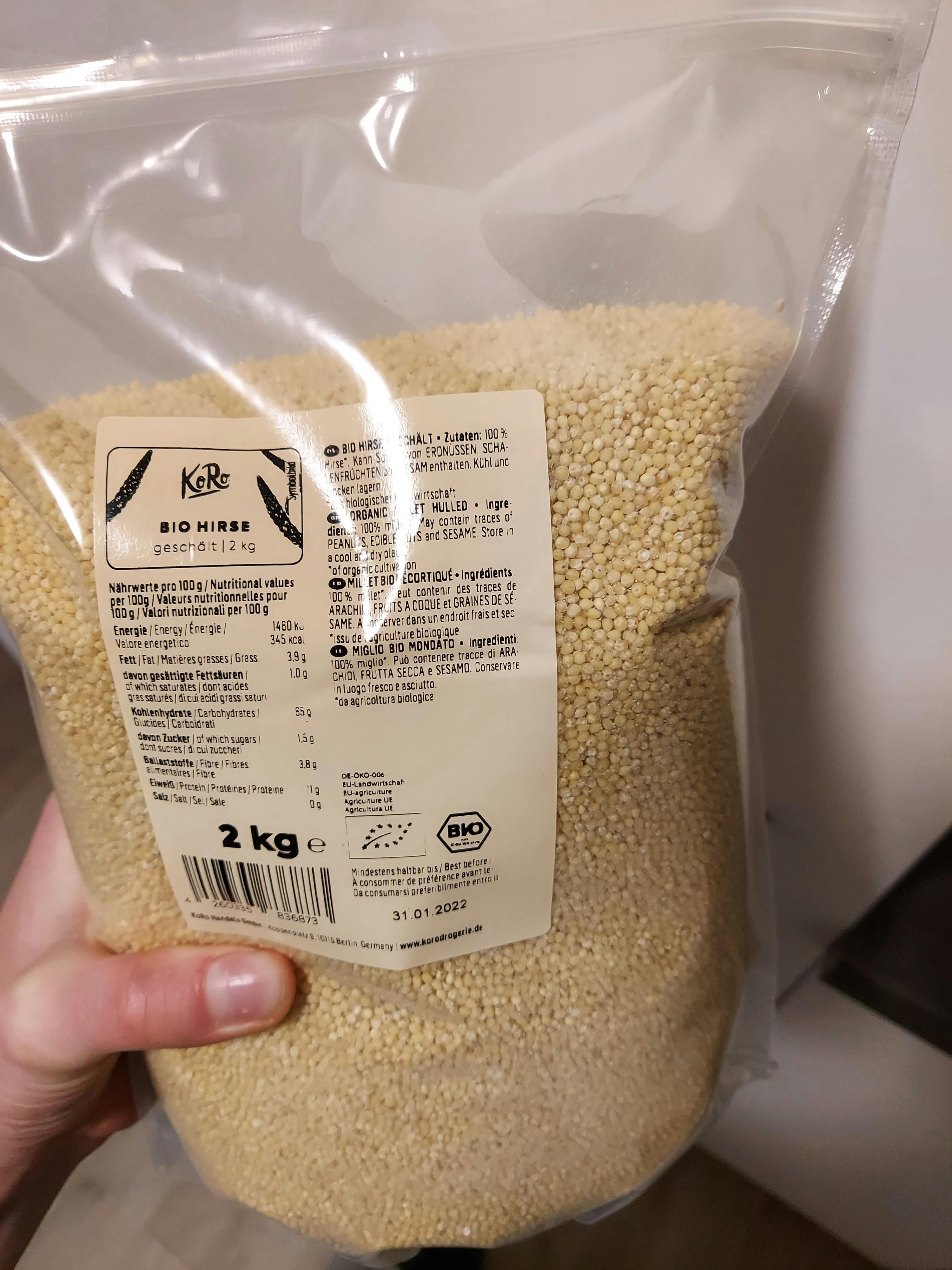 a person holding a bag of bio hires grains