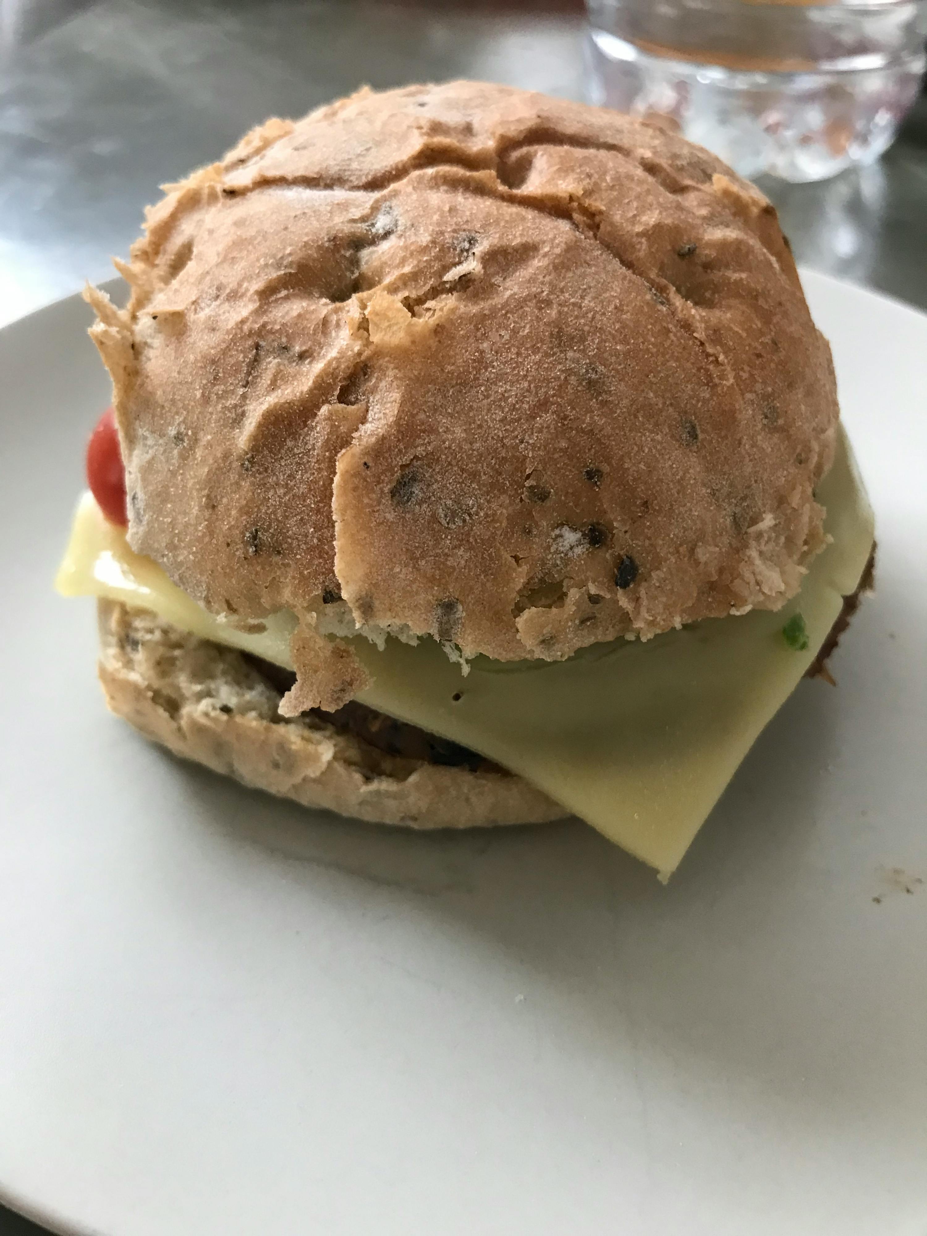 a close up of a sandwich with cheese on a white plate