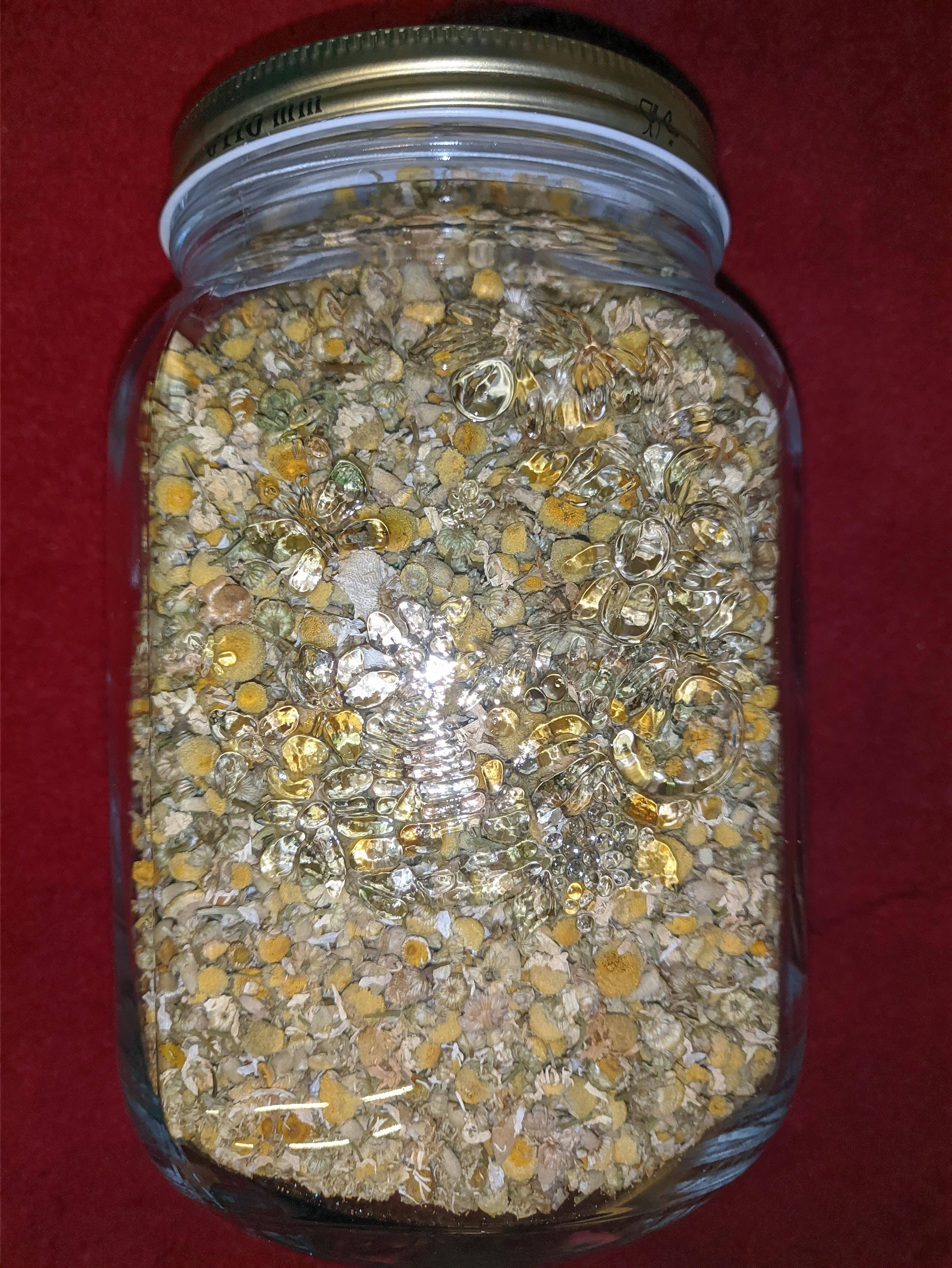 ein Glasgefäß gefüllt mit verschiedenen trockenen Kräutern