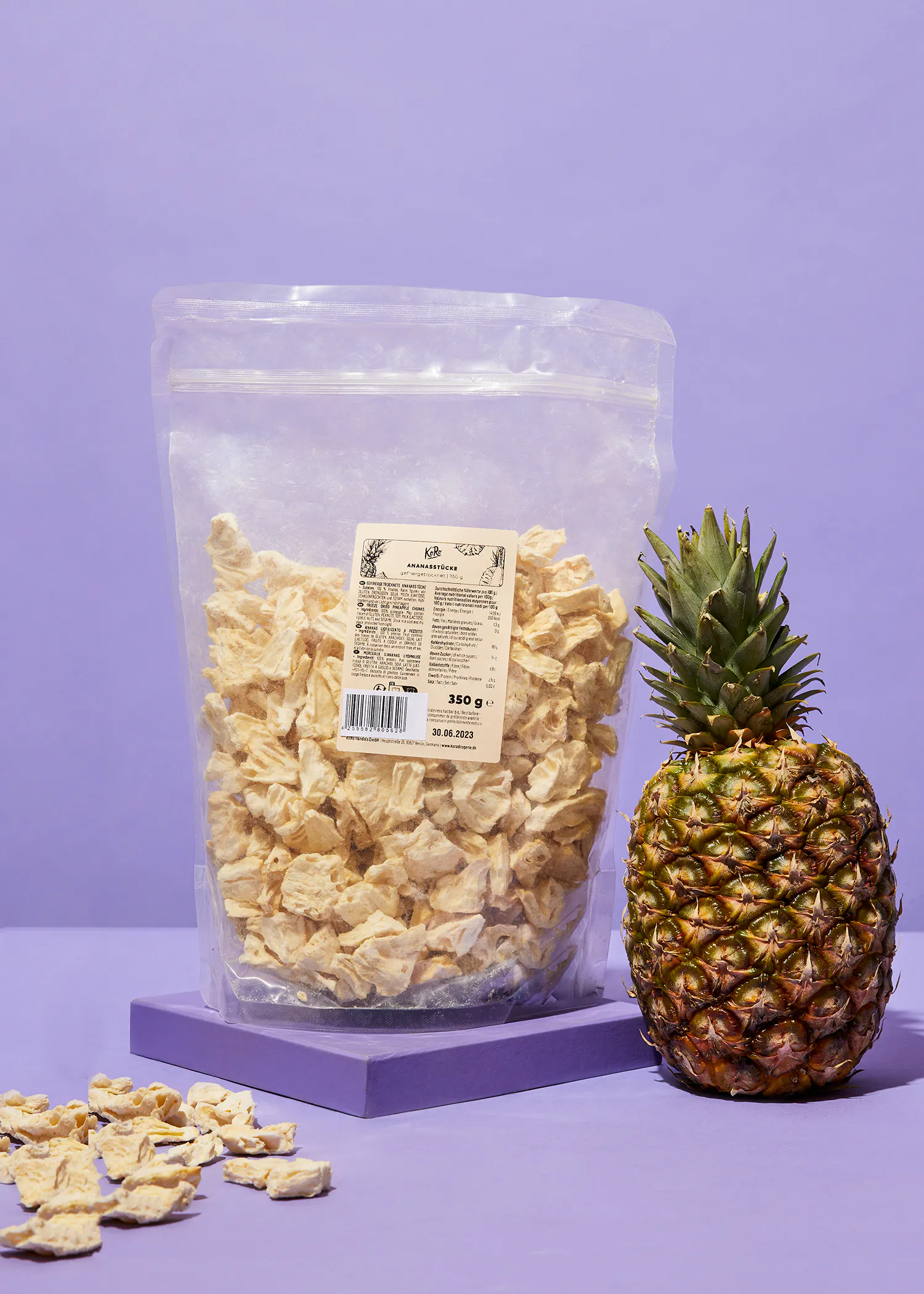 a bag of dried pineapple chips sits next to a pineapple