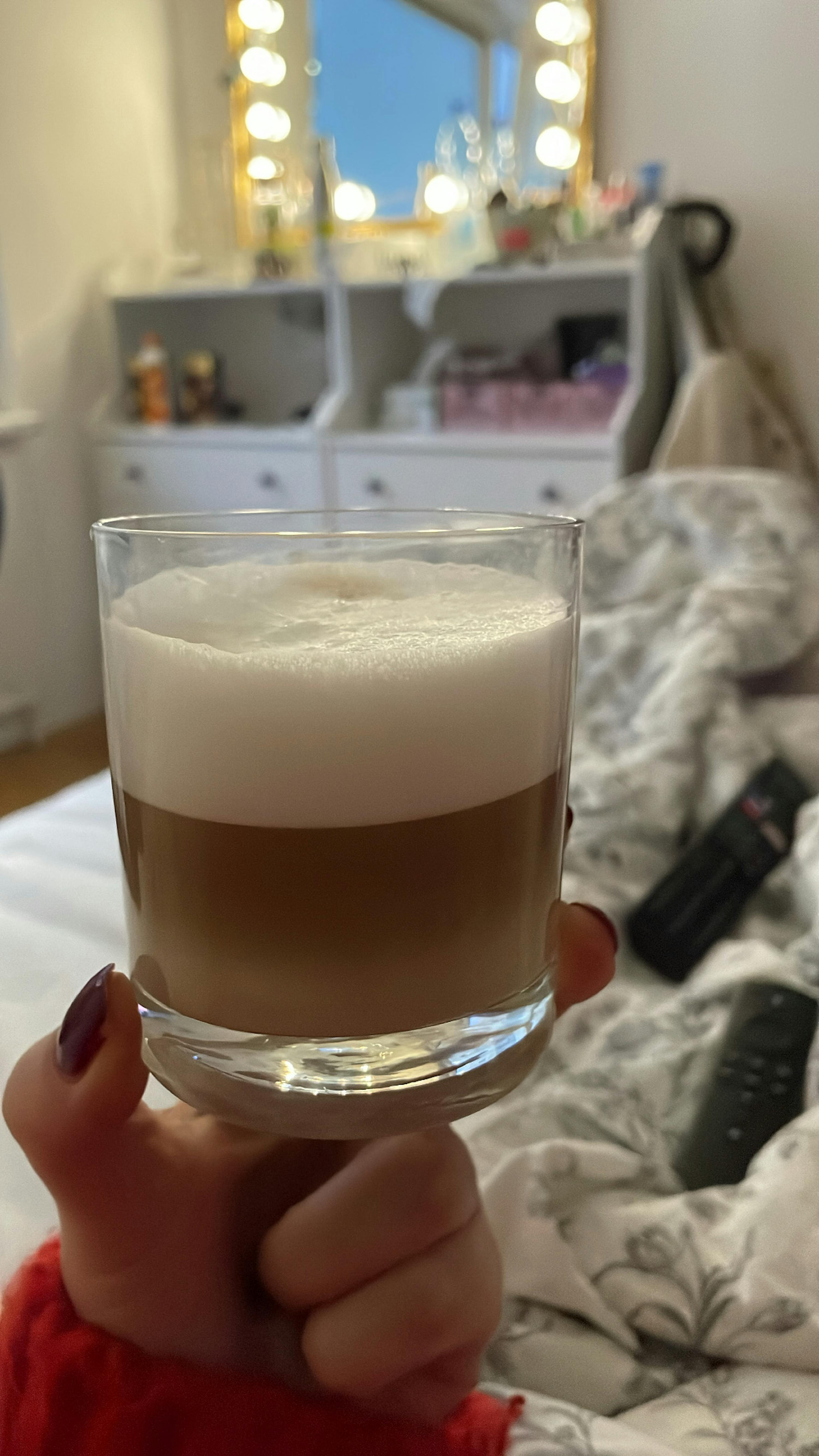 une personne tient un verre rempli de cappuccino