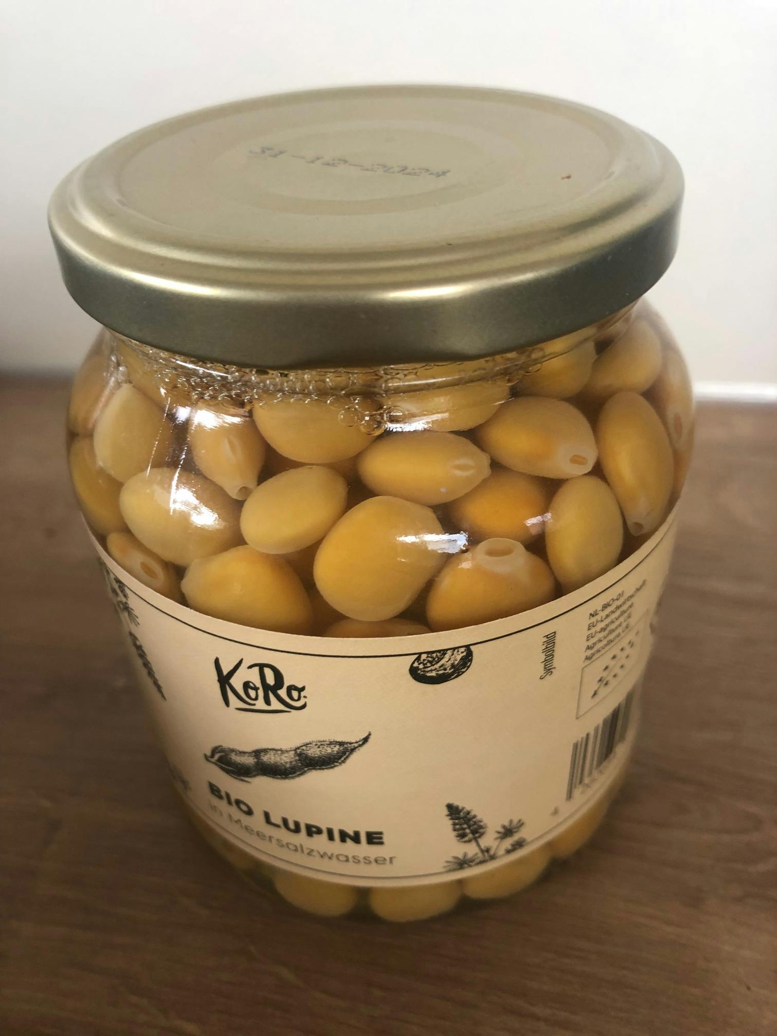 un bocal en verre rempli de lupins avec une étiquette blanche