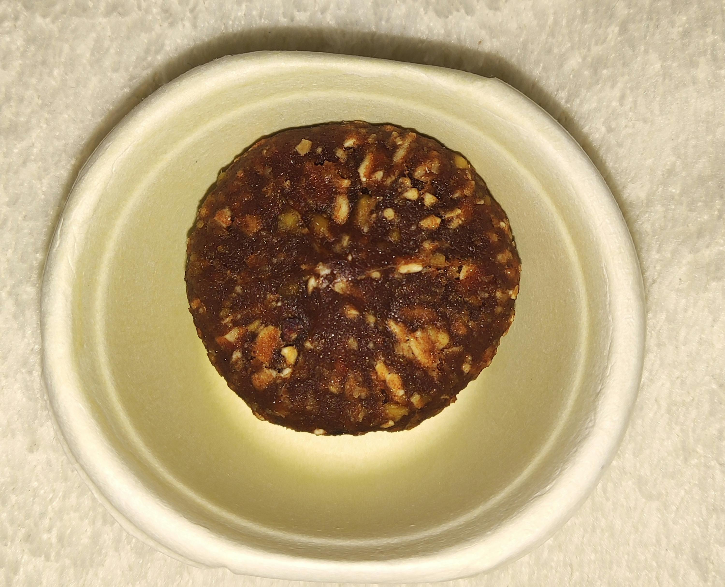 ein kleiner weißer Teller mit einem braunen Bällchen darin