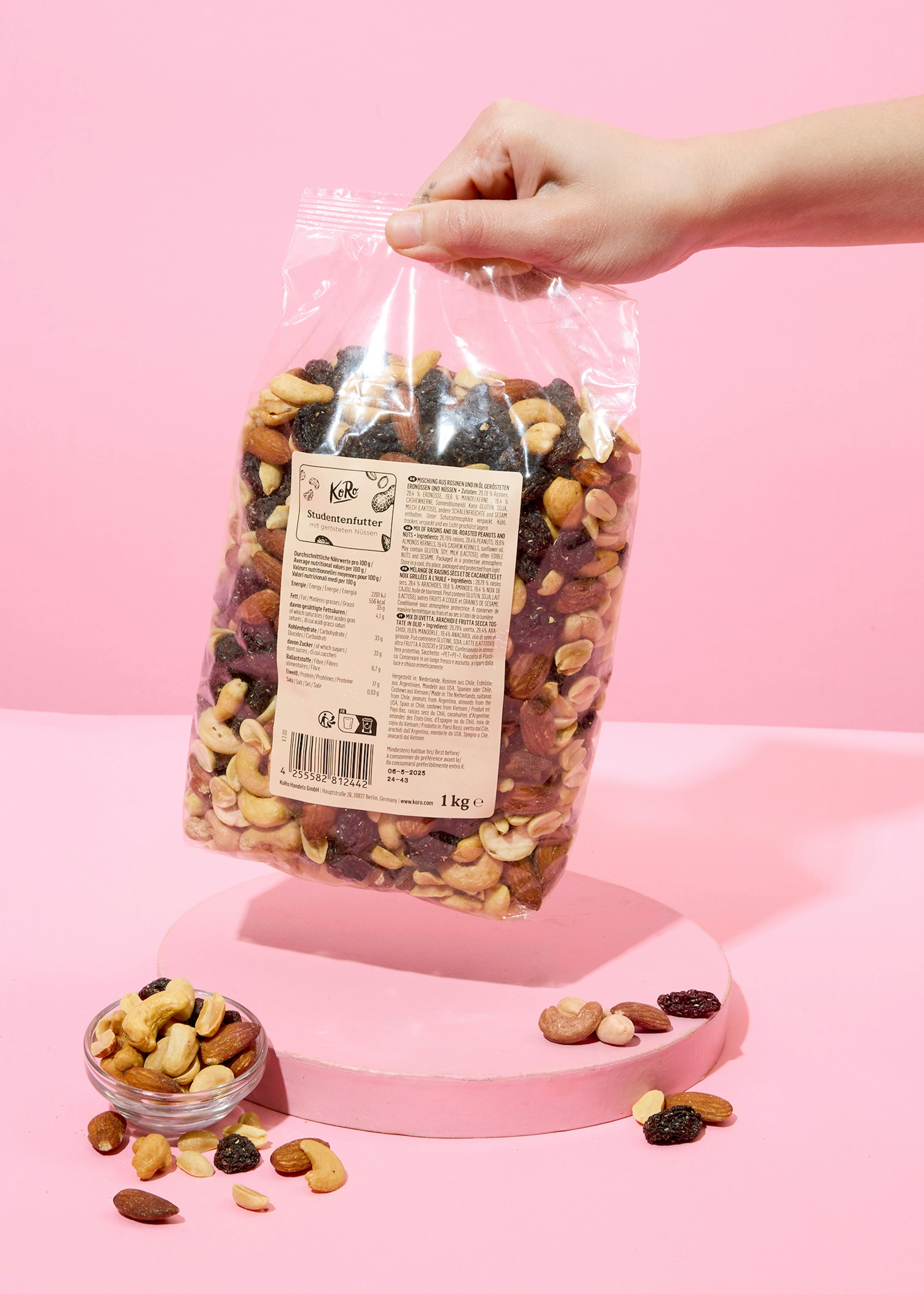 a person is holding a bag of nuts and raisins