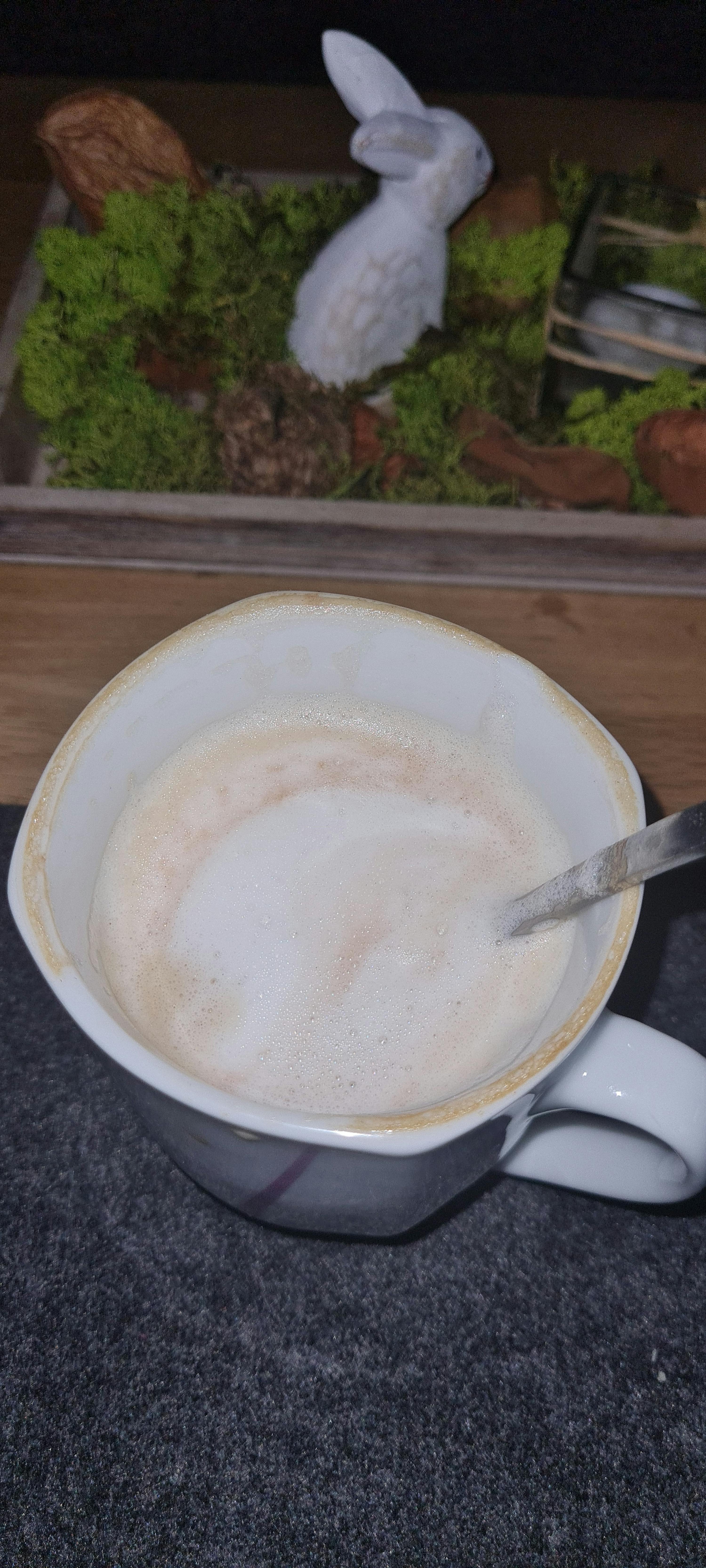 una tazza di caffè con un cucchiaio in cima