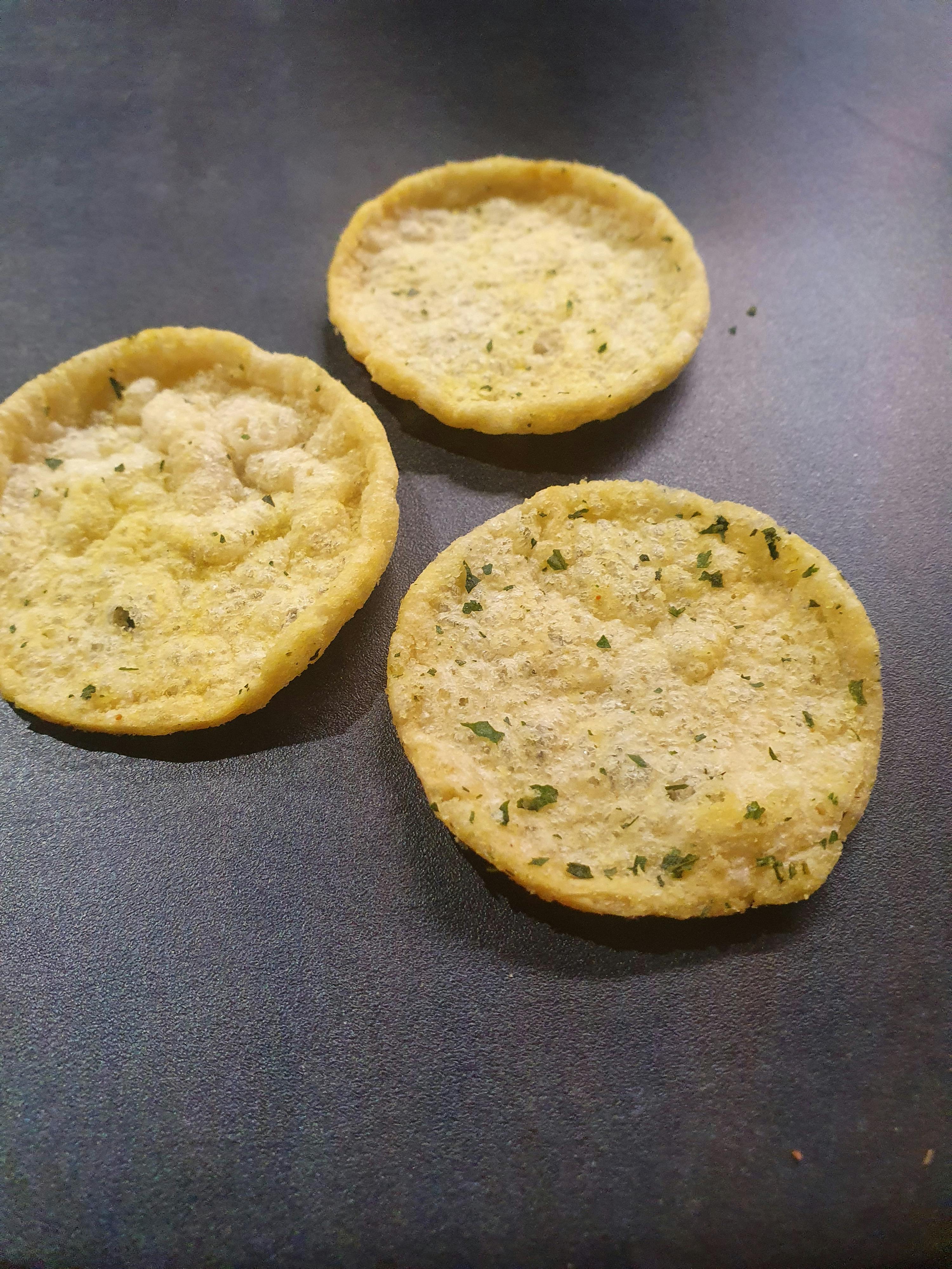 three tortilla chips are on a black surface