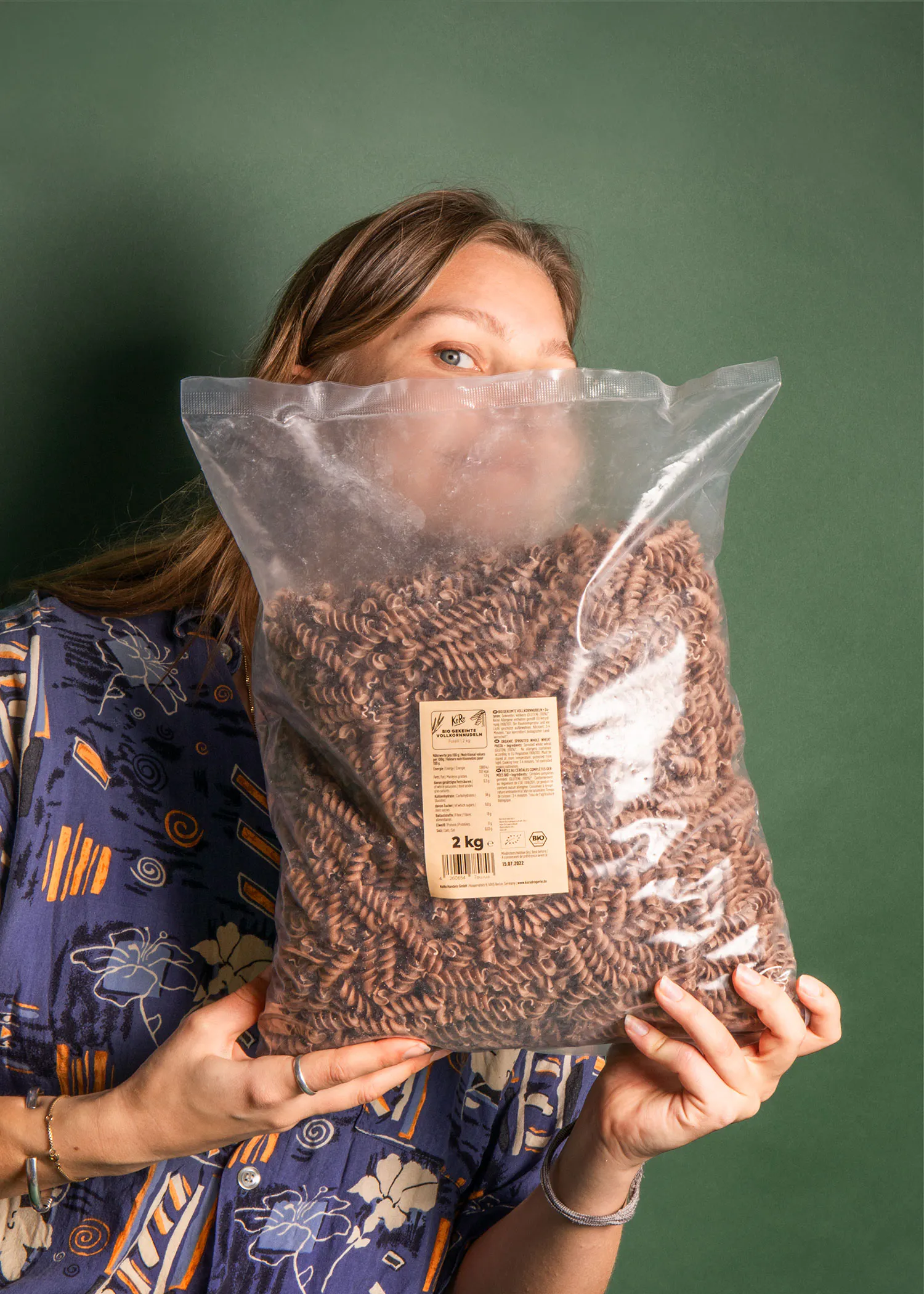 eine Frau hält einen Plastiksack mit Nudeln in der Hand