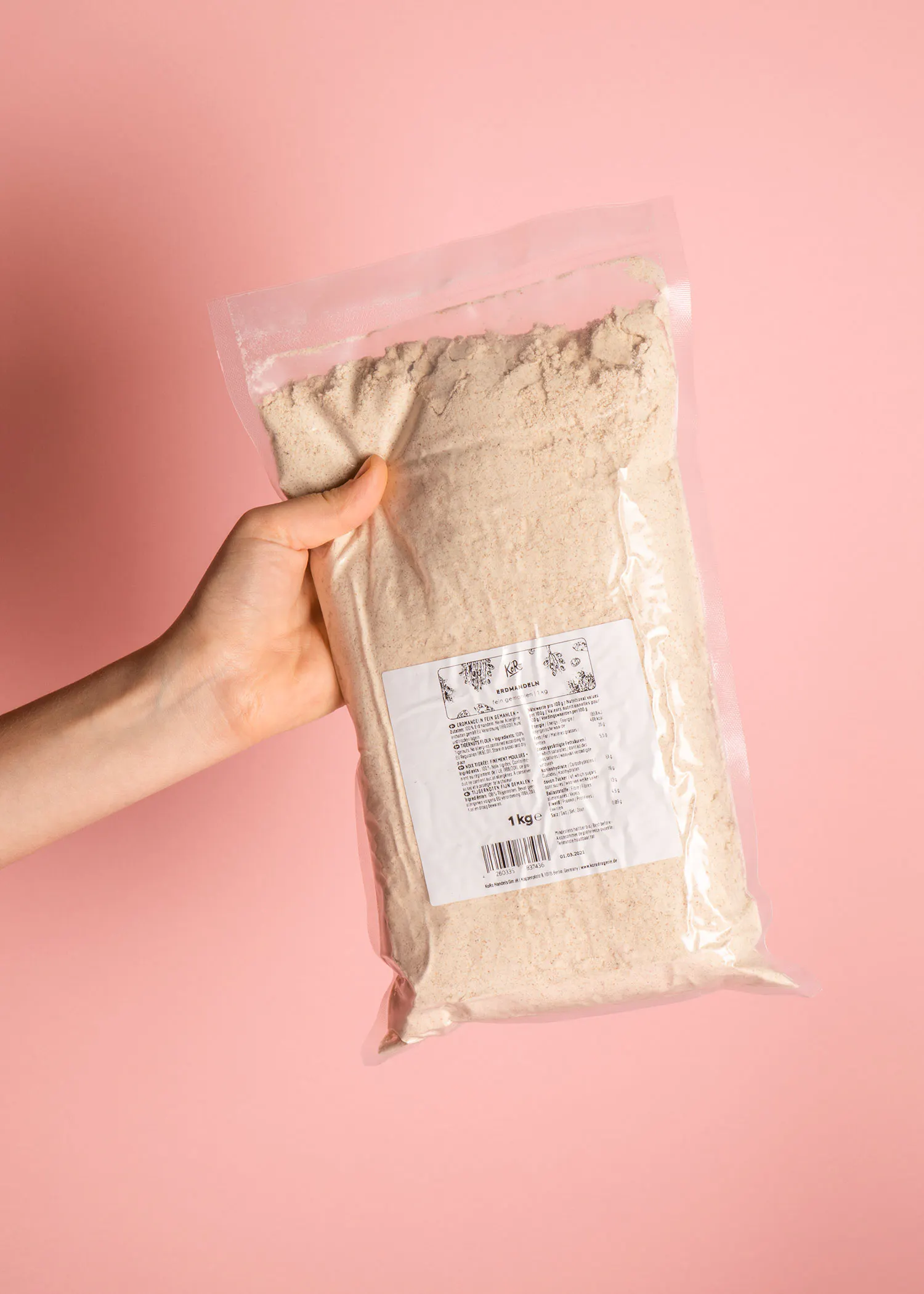 une personne tient un sac de farine blanche sur fond rose