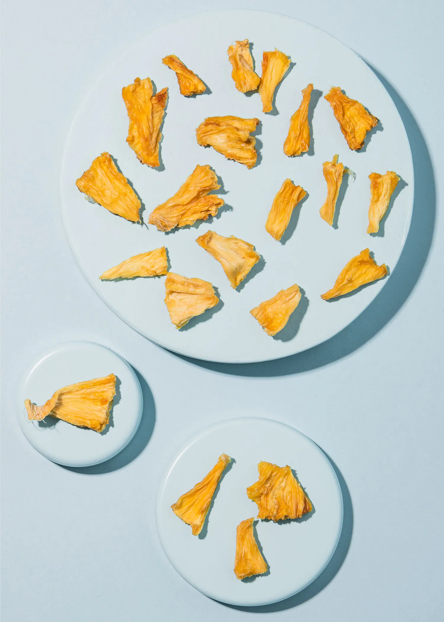 drei weiße Teller mit getrockneten Früchten auf einem Tisch