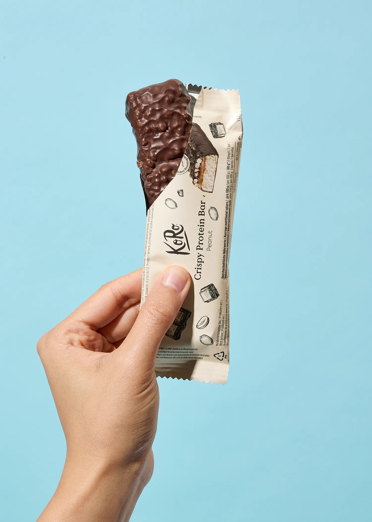 une personne tient une barre de protéines croustillante