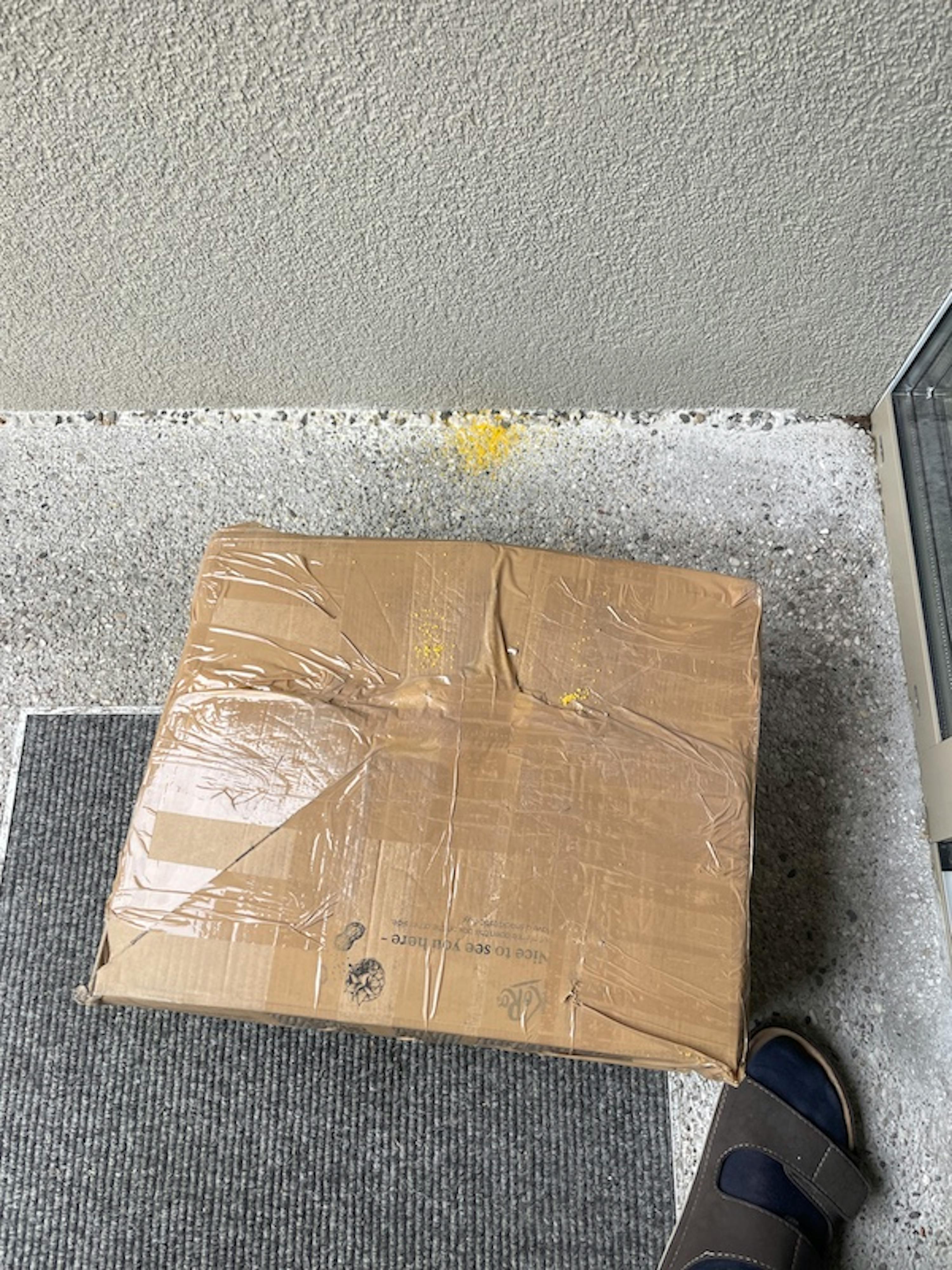 ein brauner karton mit klebeband darauf steht auf einem teppich