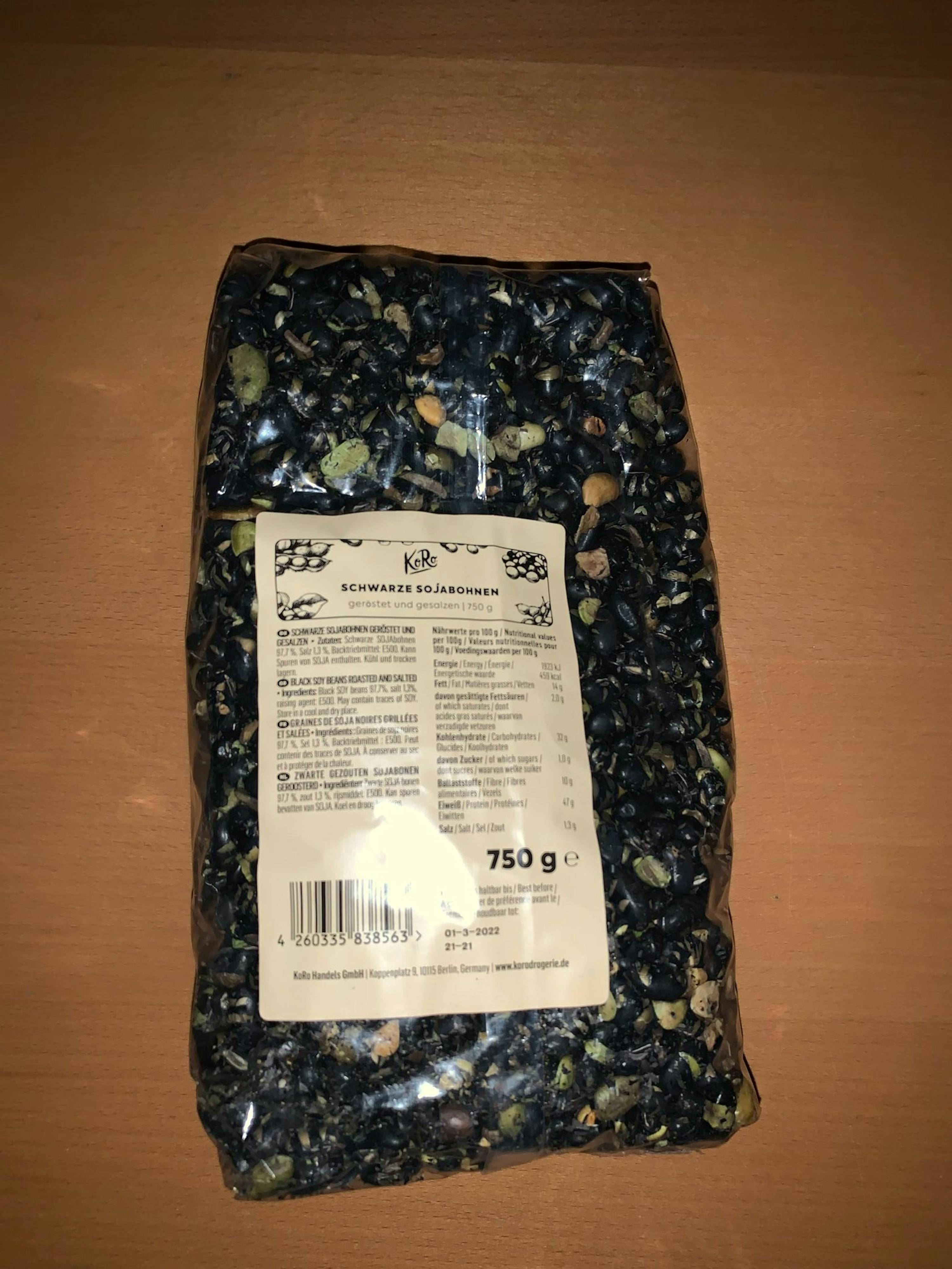 eine verpackte schwarze sojabohnen liegt auf einem braunen tisch
