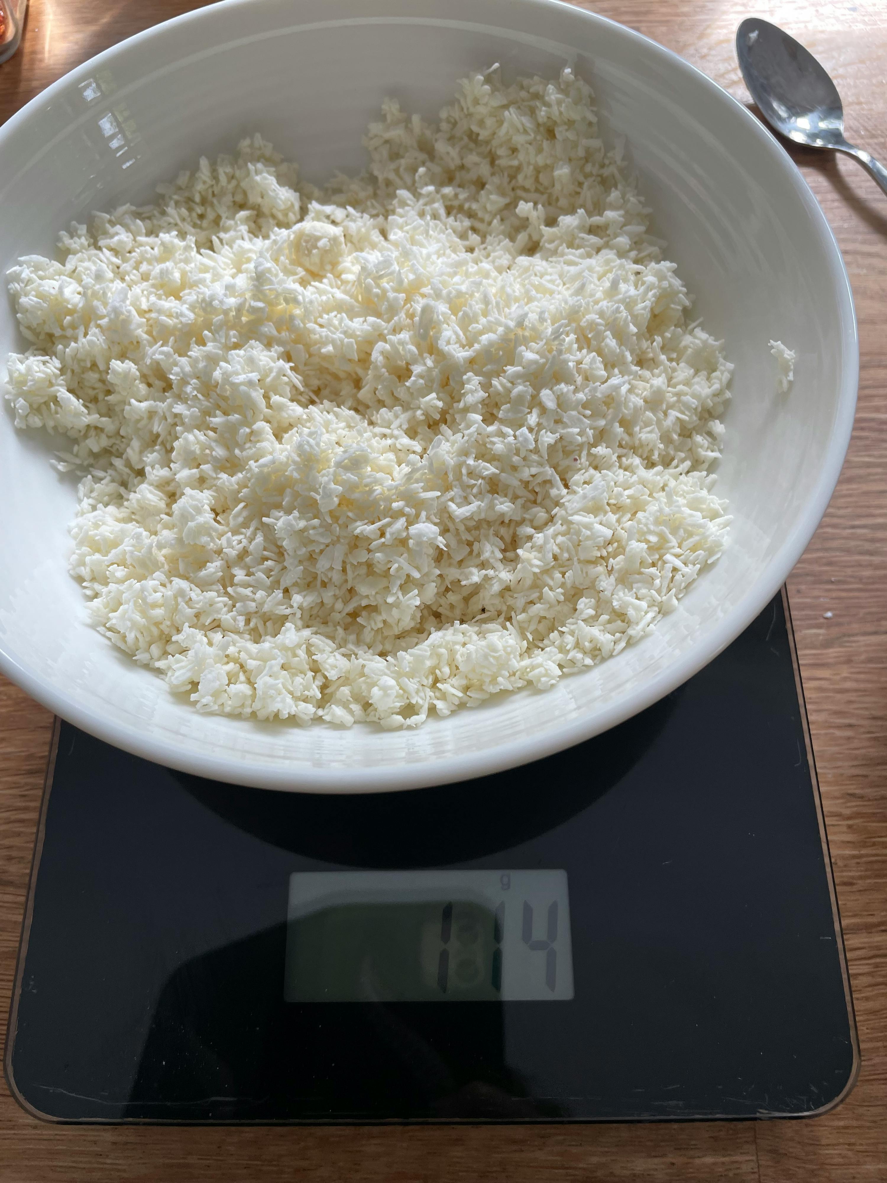 eine weiße Schüssel mit weißem Pulver steht auf einer schwarzen Waage